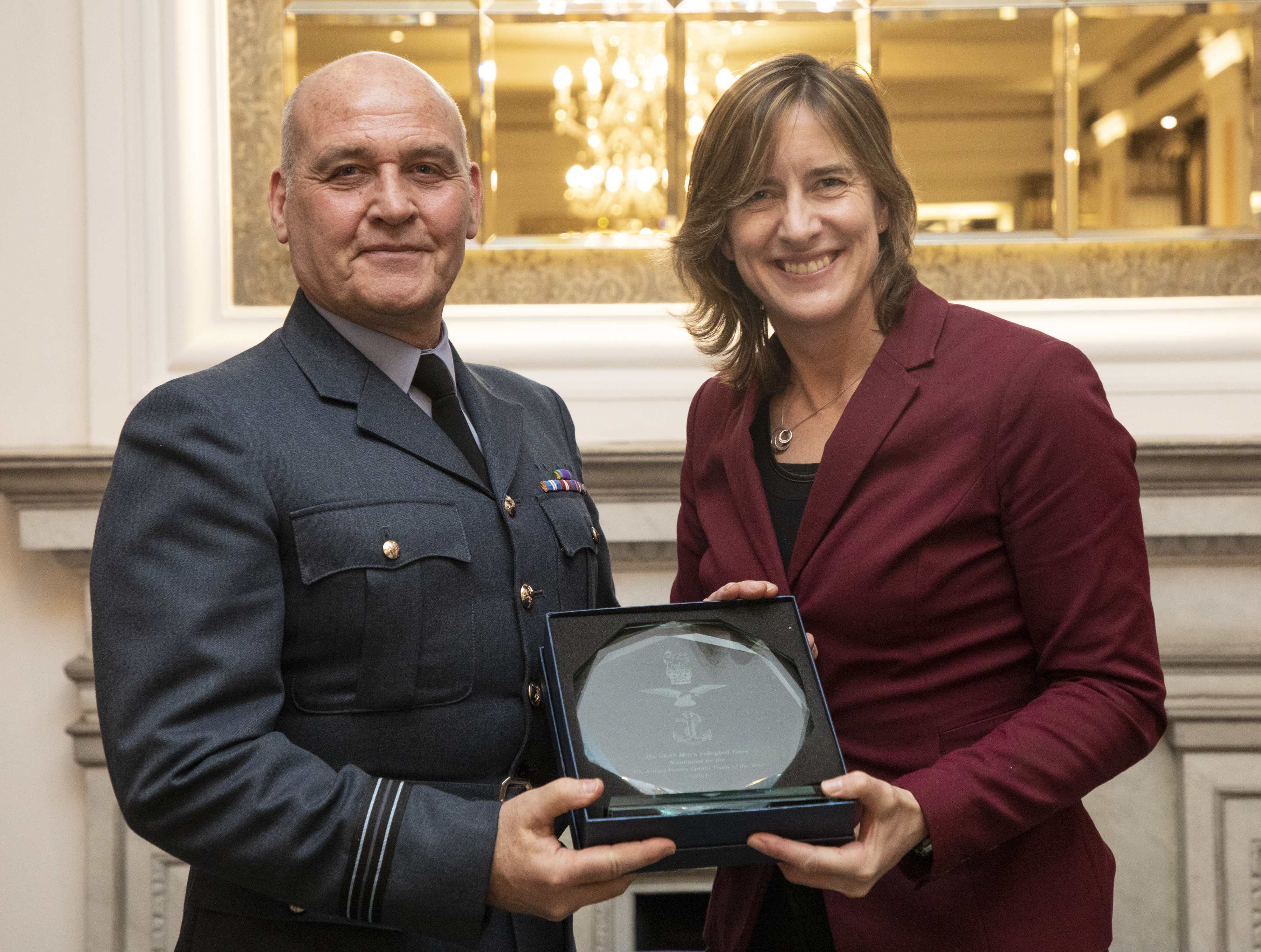Caroline presents Mark with his award.