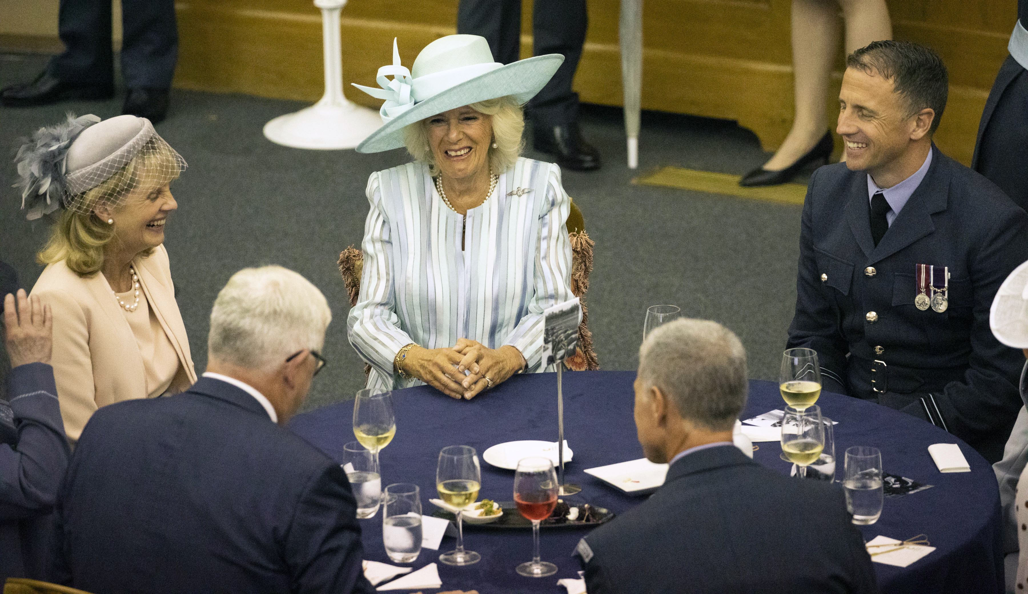 Her Royal Highness sits at a table with others.