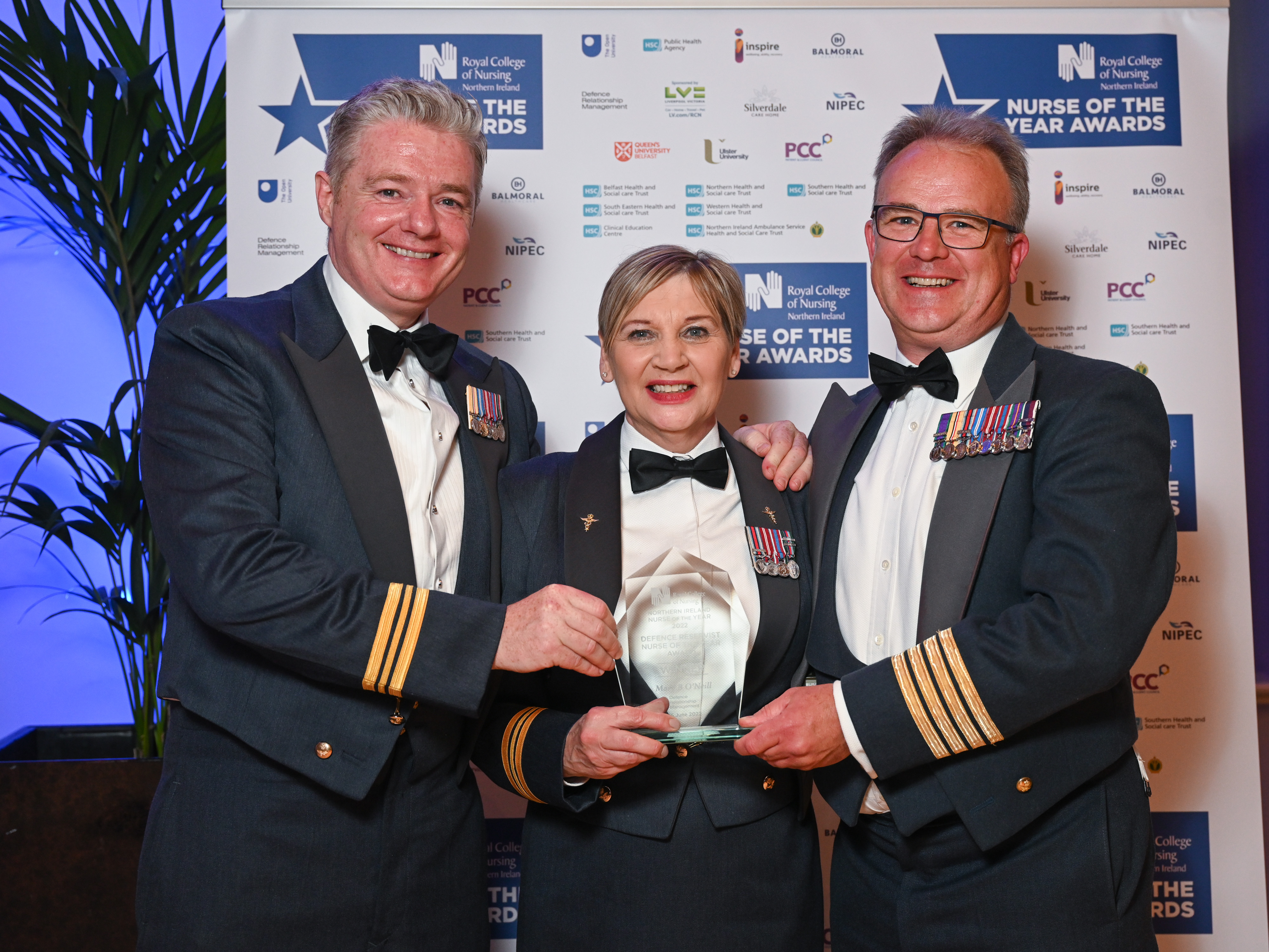 Mary holds award with two other aviators.