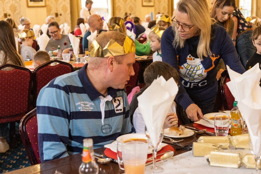 Image shows families having a Christmas Dinner