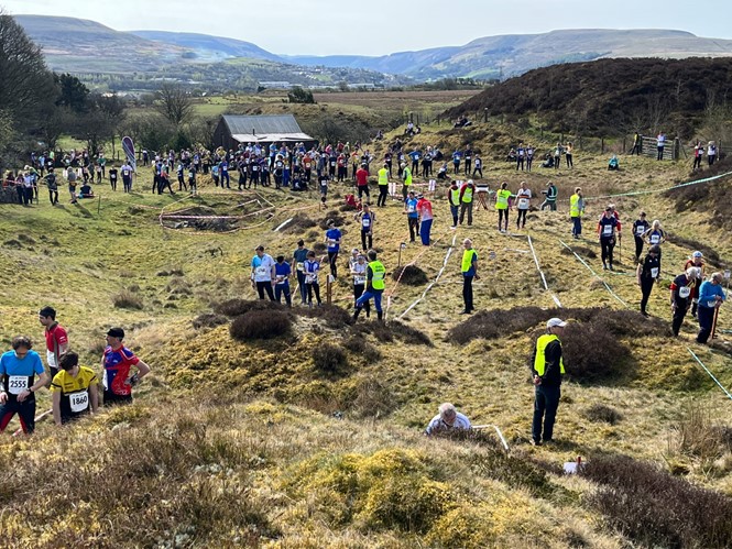 Orienteers walking on the grass in moorlands.