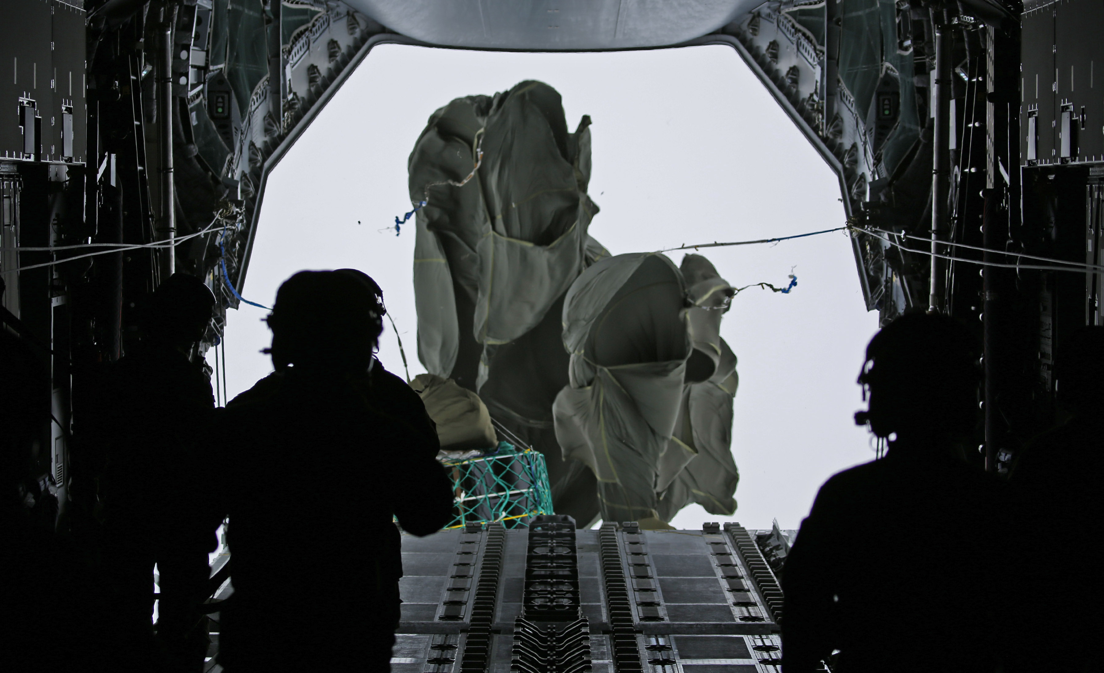 Image shows RAF aviators dropping cargo from the holding bay of carrier aircraft.