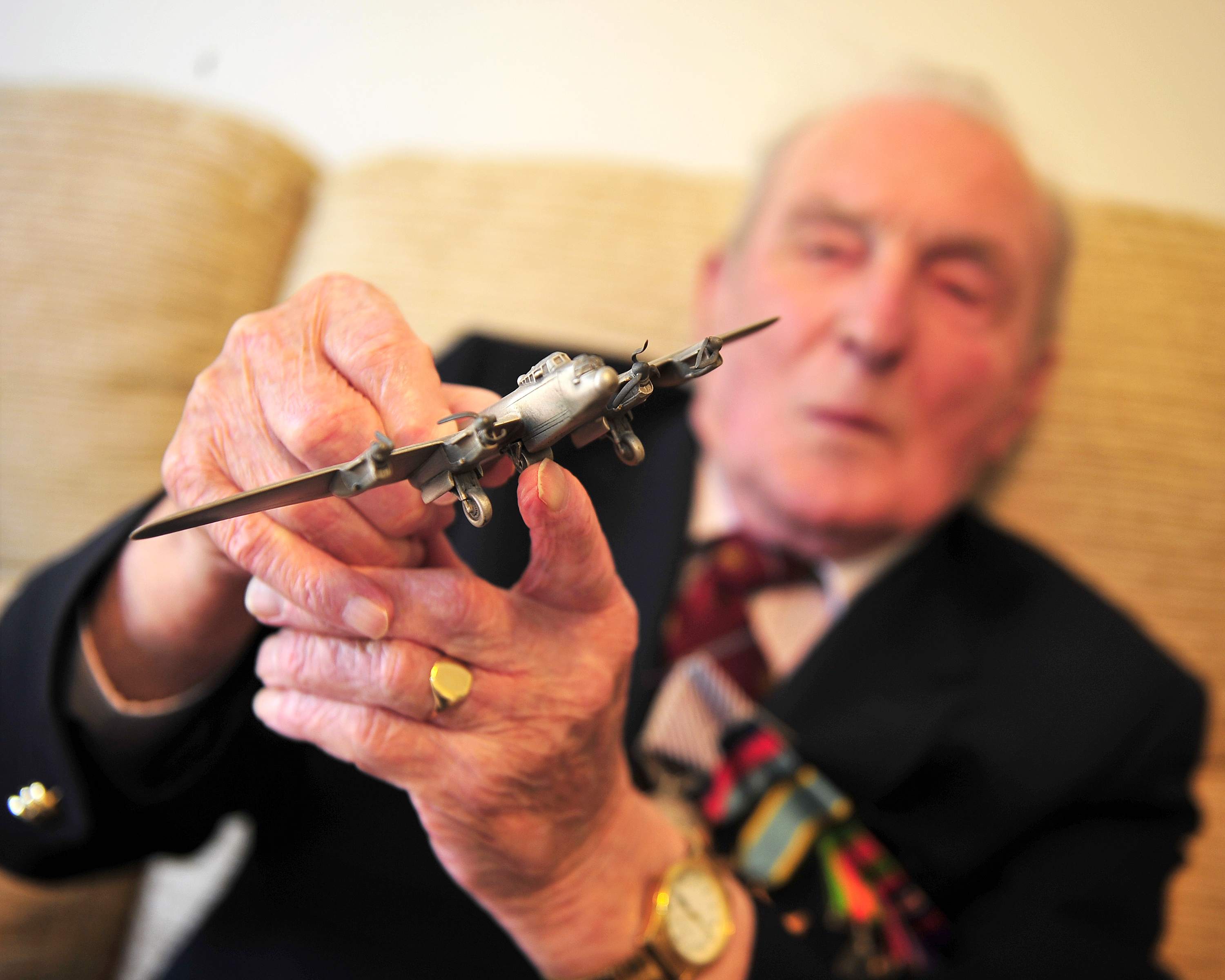 Johnny holds a model Lancaster Aircraft to the camera.