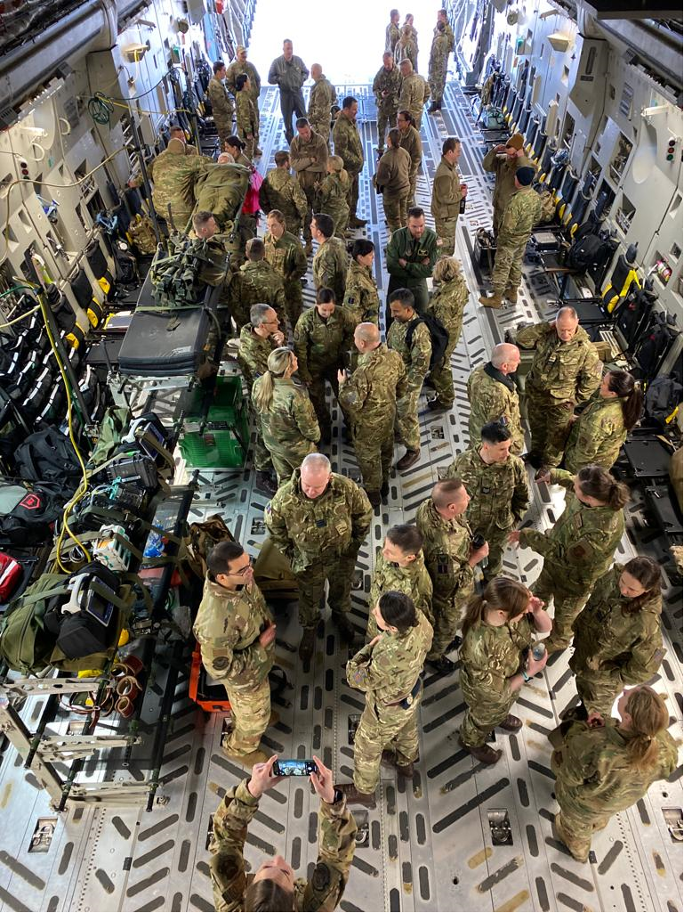 Personnel inside C-17 aircraft carrier, with medical equipment.