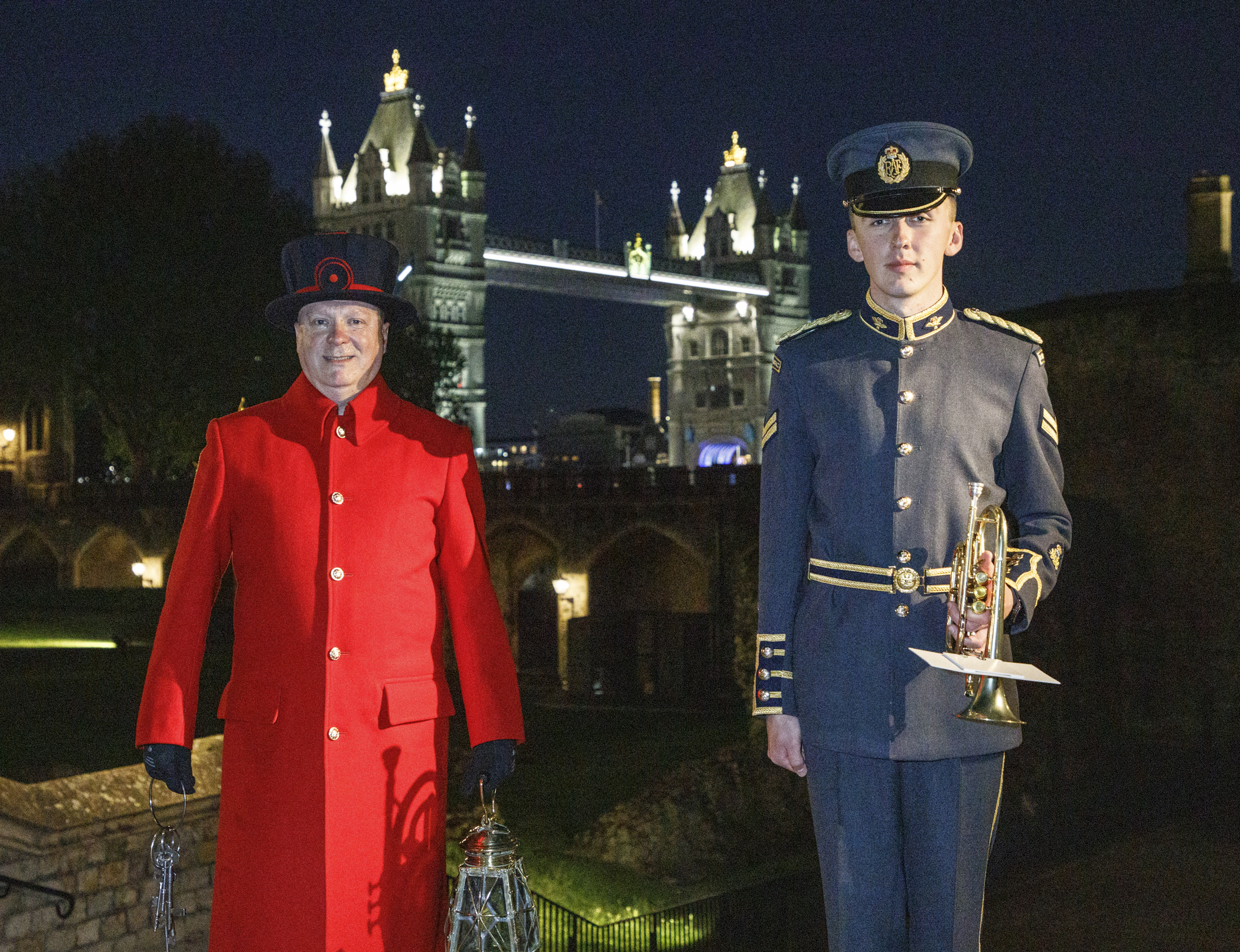 Yeoman Warder and RAF trumpeter stand by the Tower of London.