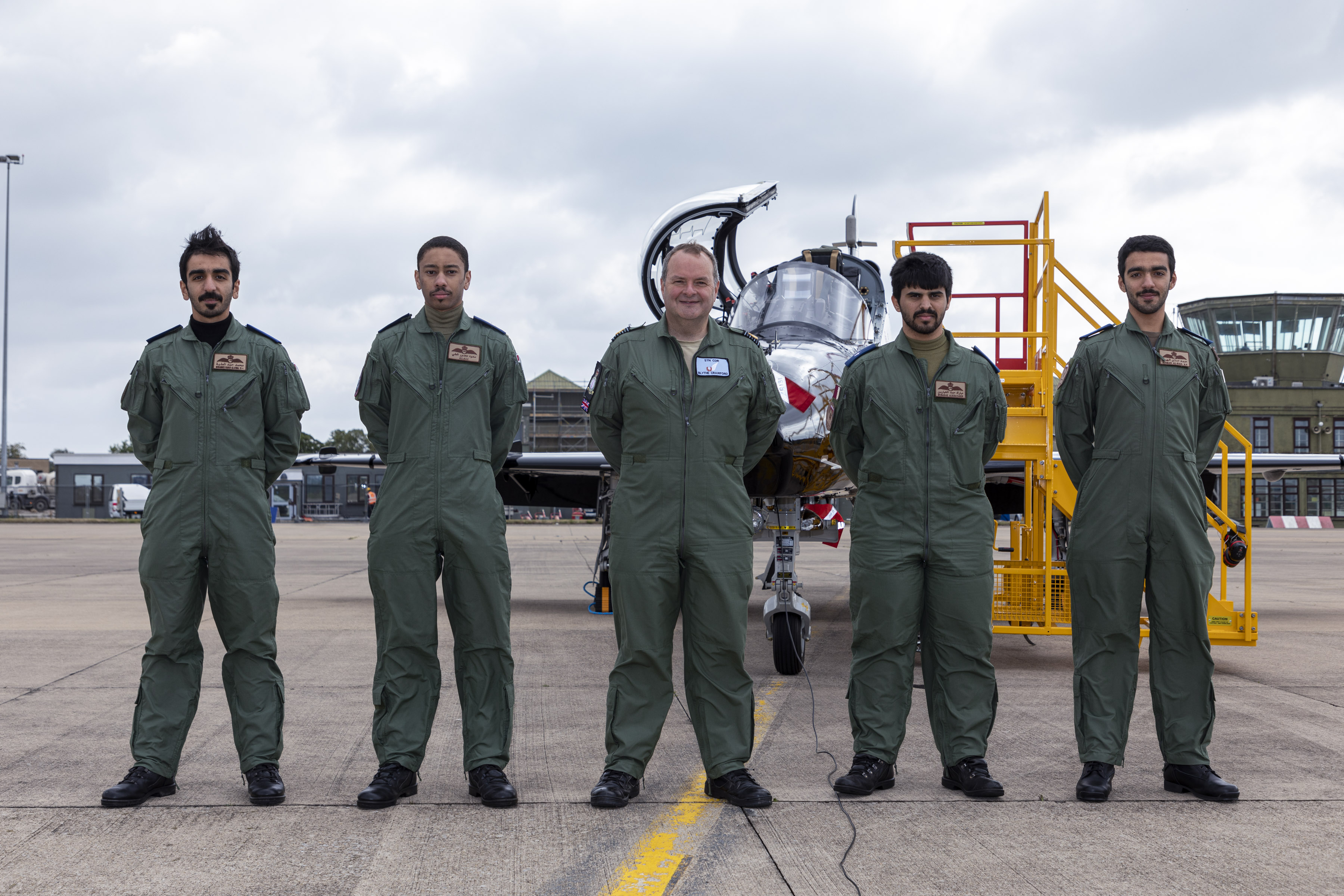Personnel stand before a new Qatari Hawk aircraft and ramp.