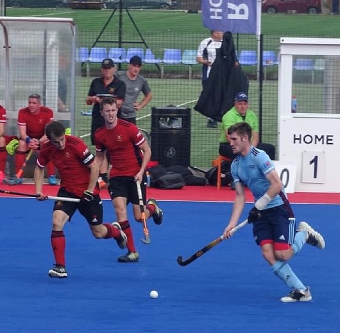 Image shows hockey players on the pitch during a game.