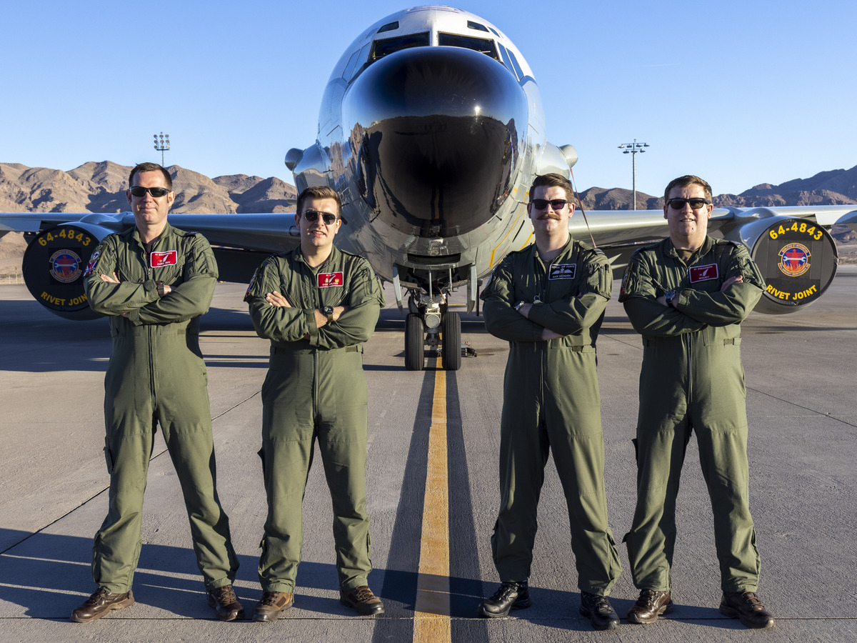 Image shows the aircrew standing by the front nose end of a Rivet Joint aircraft.