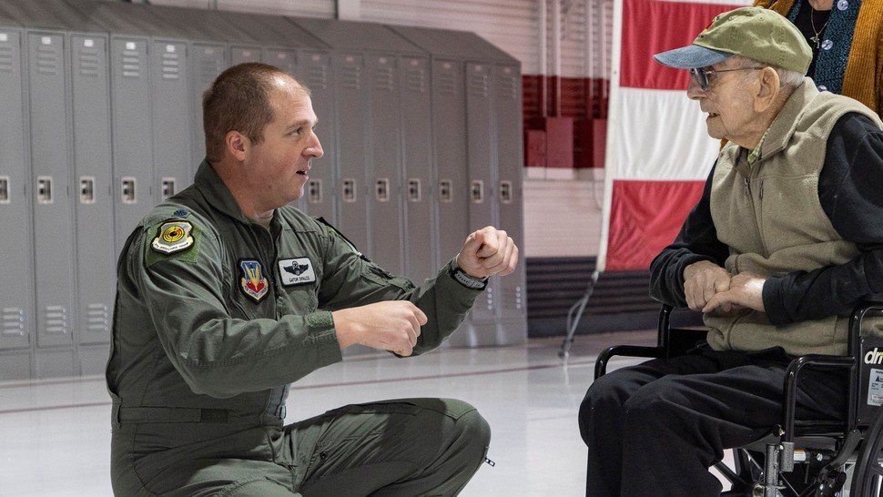 Image shows RAF Veteran in wheelchair and United States Air Force personnel inside Thunderbirds museum.