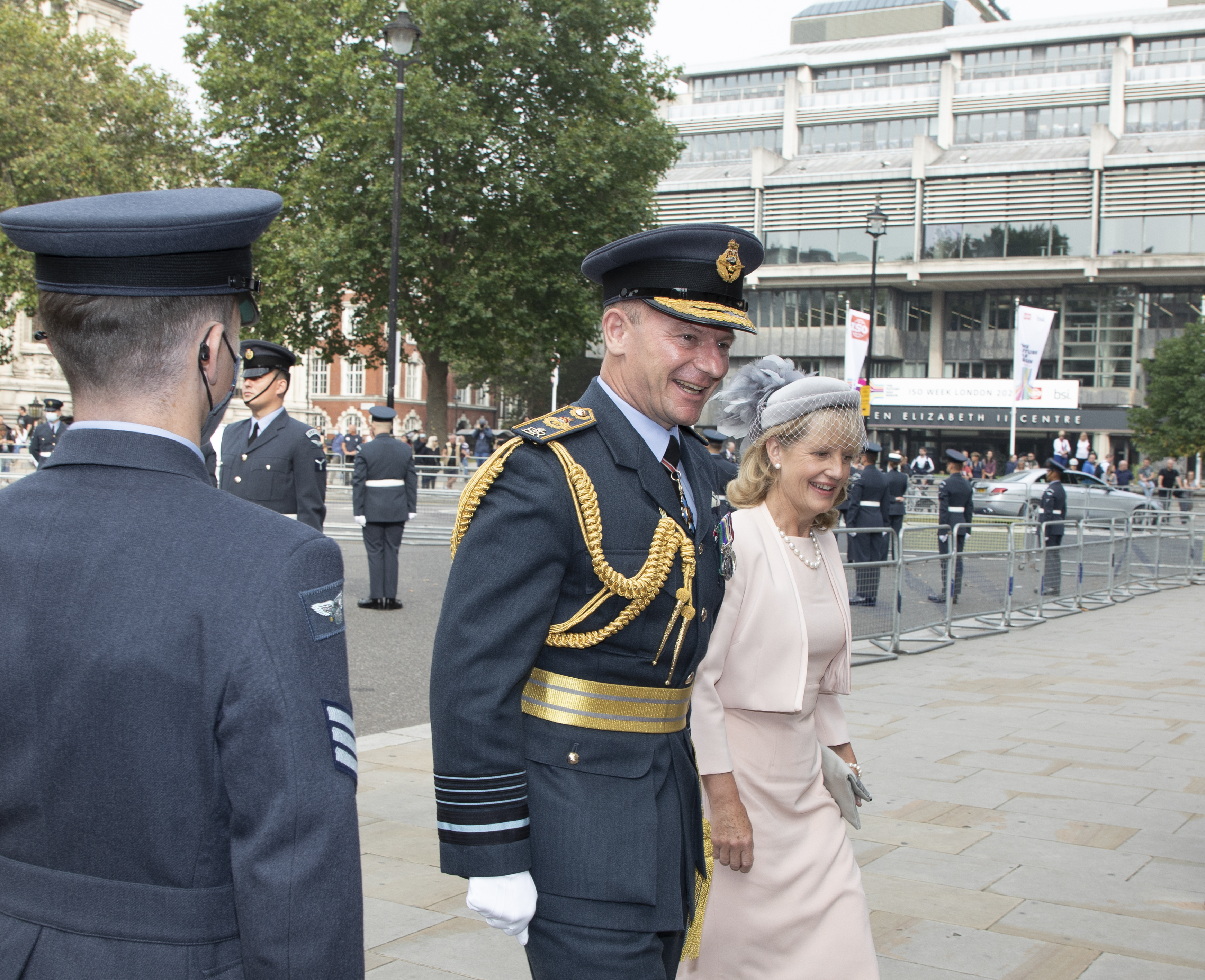 Air Chief Marshal walks with wife towards Westminster Abbey.