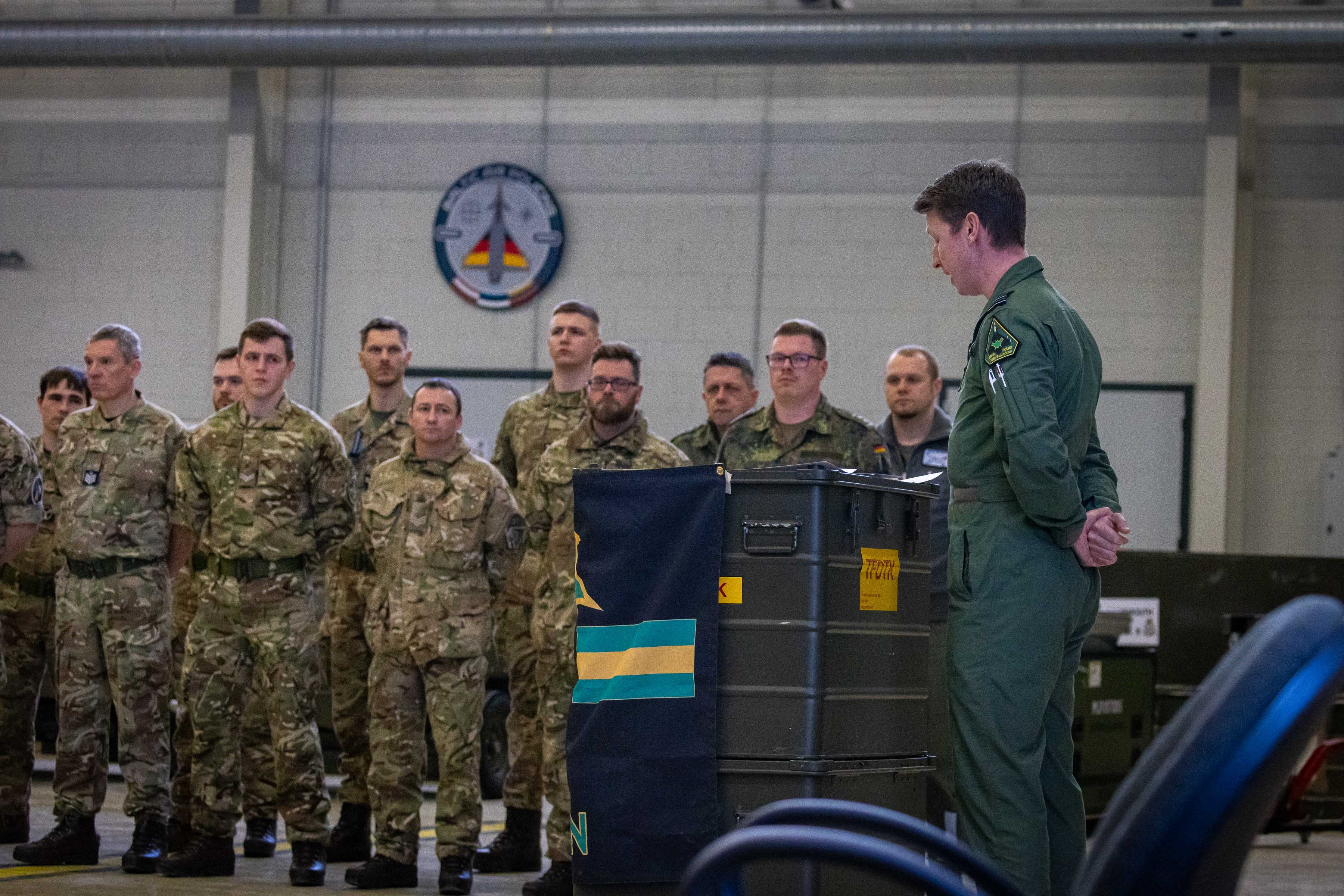 Image shows RAF personnel standing inside hangar.
