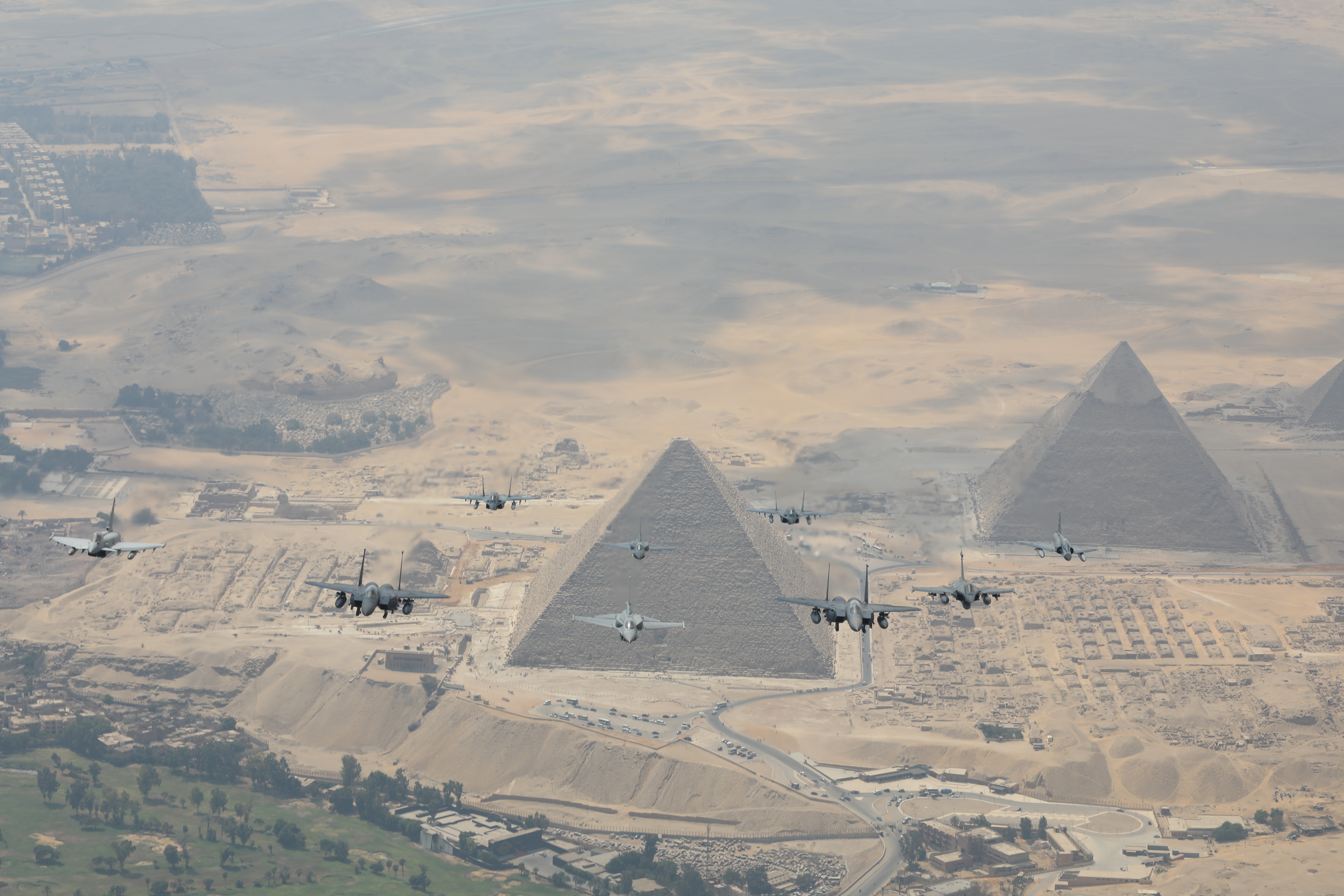RAF and Egyptian aircraft fly in formation over Egyptian pyramids. 