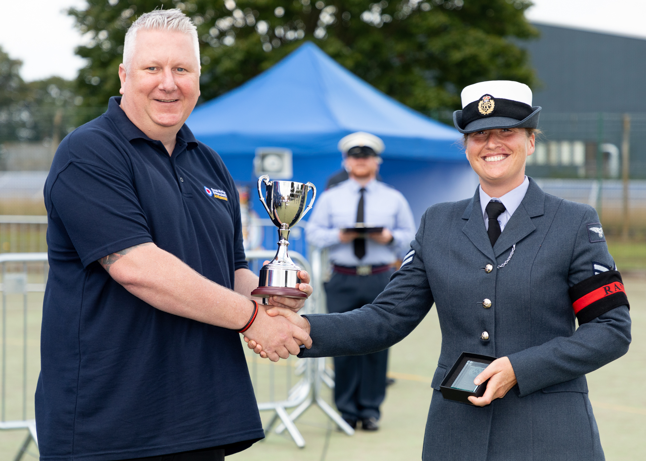 RAF Police Handler shakes hands while being awarded trophy.