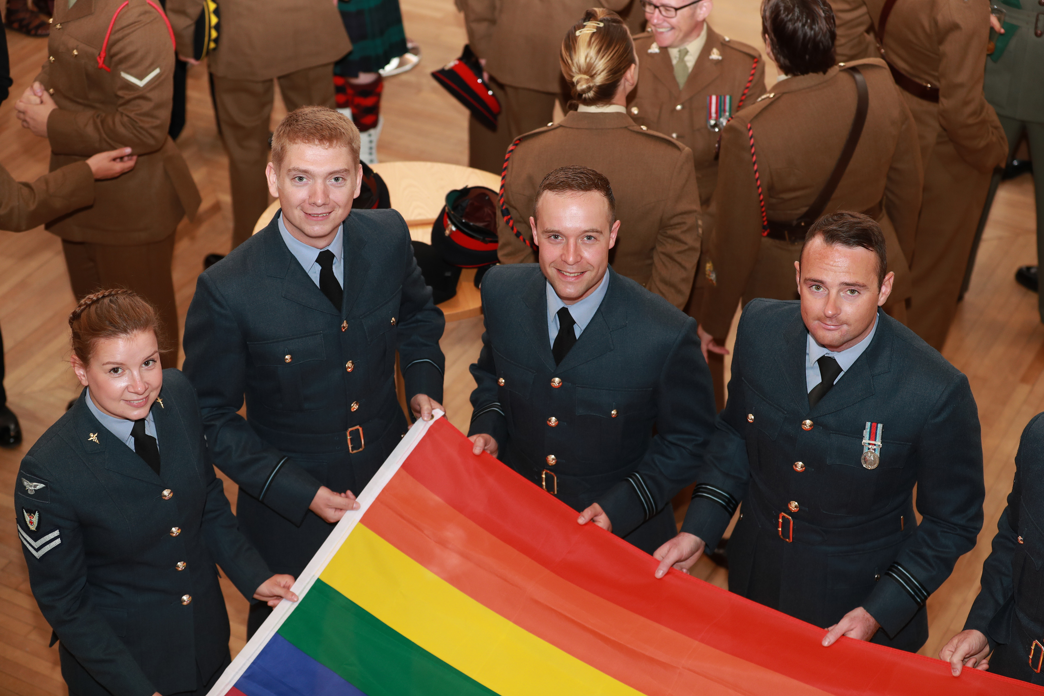 RAF Personnel hold an LGBT+ flag.