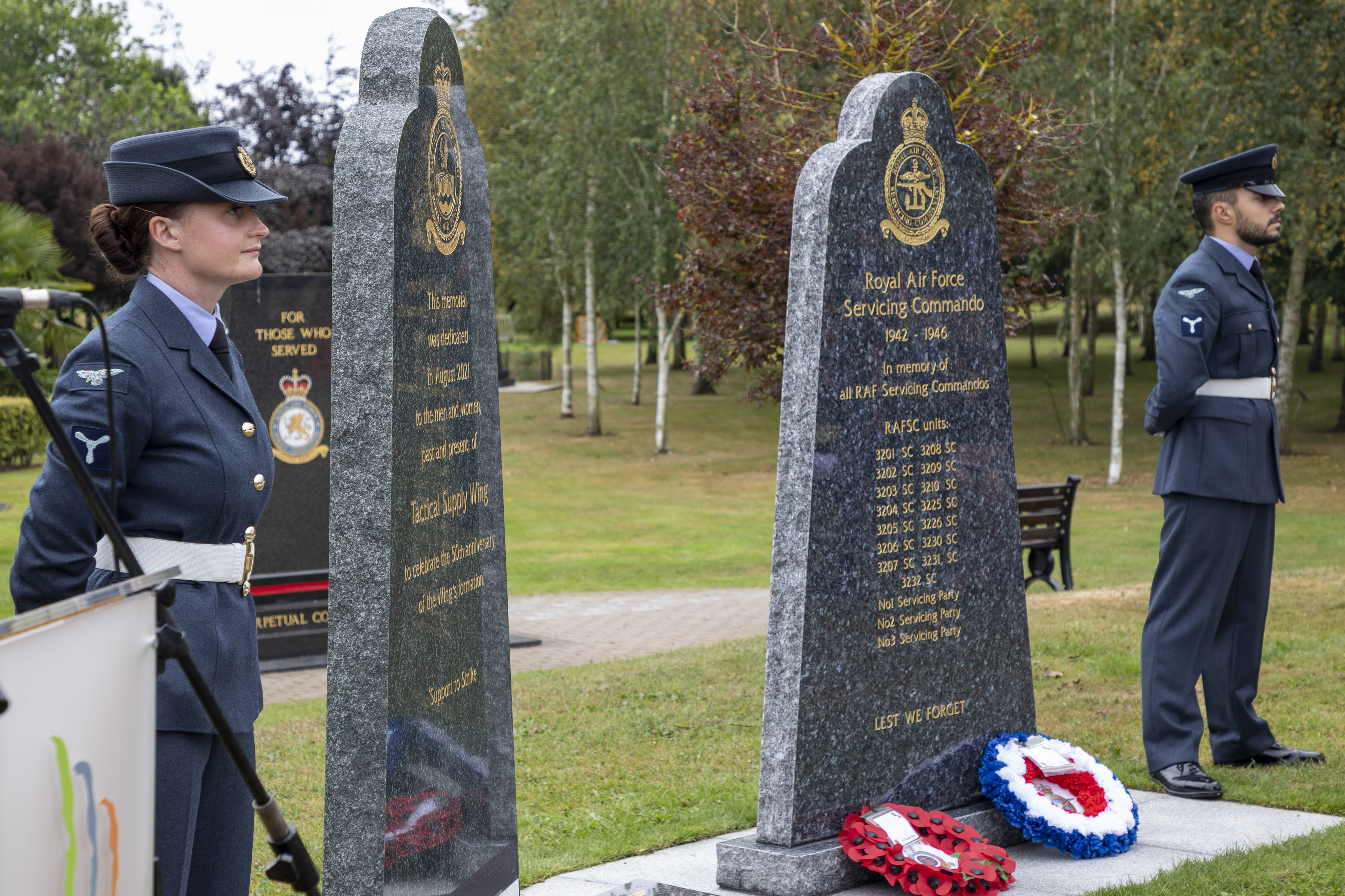 Personnel stand by memorial stone.