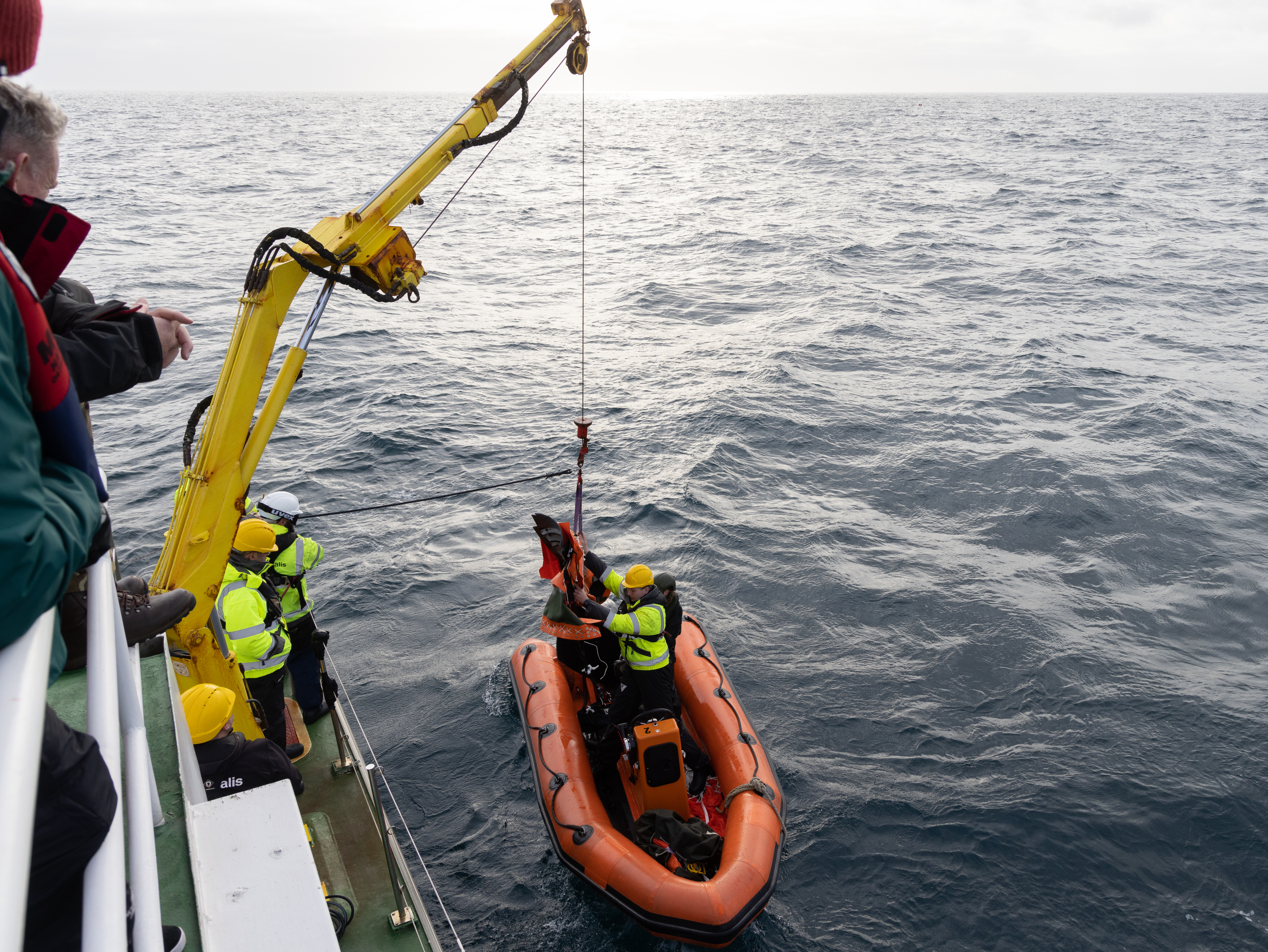 Image shows RAF Search and Rescue team lifting a lifeboat out of the sea.