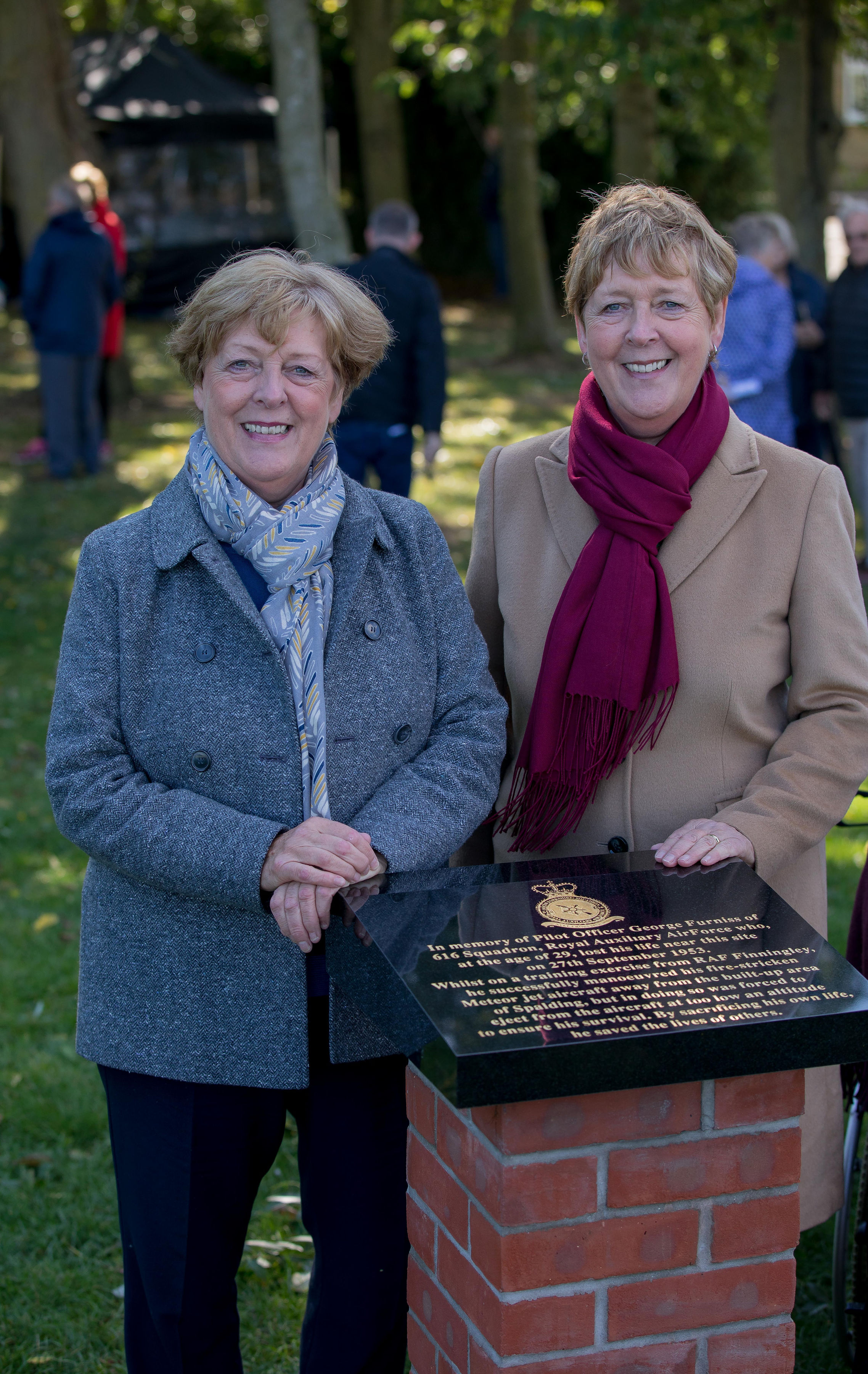 Members of the public stand by memorial.