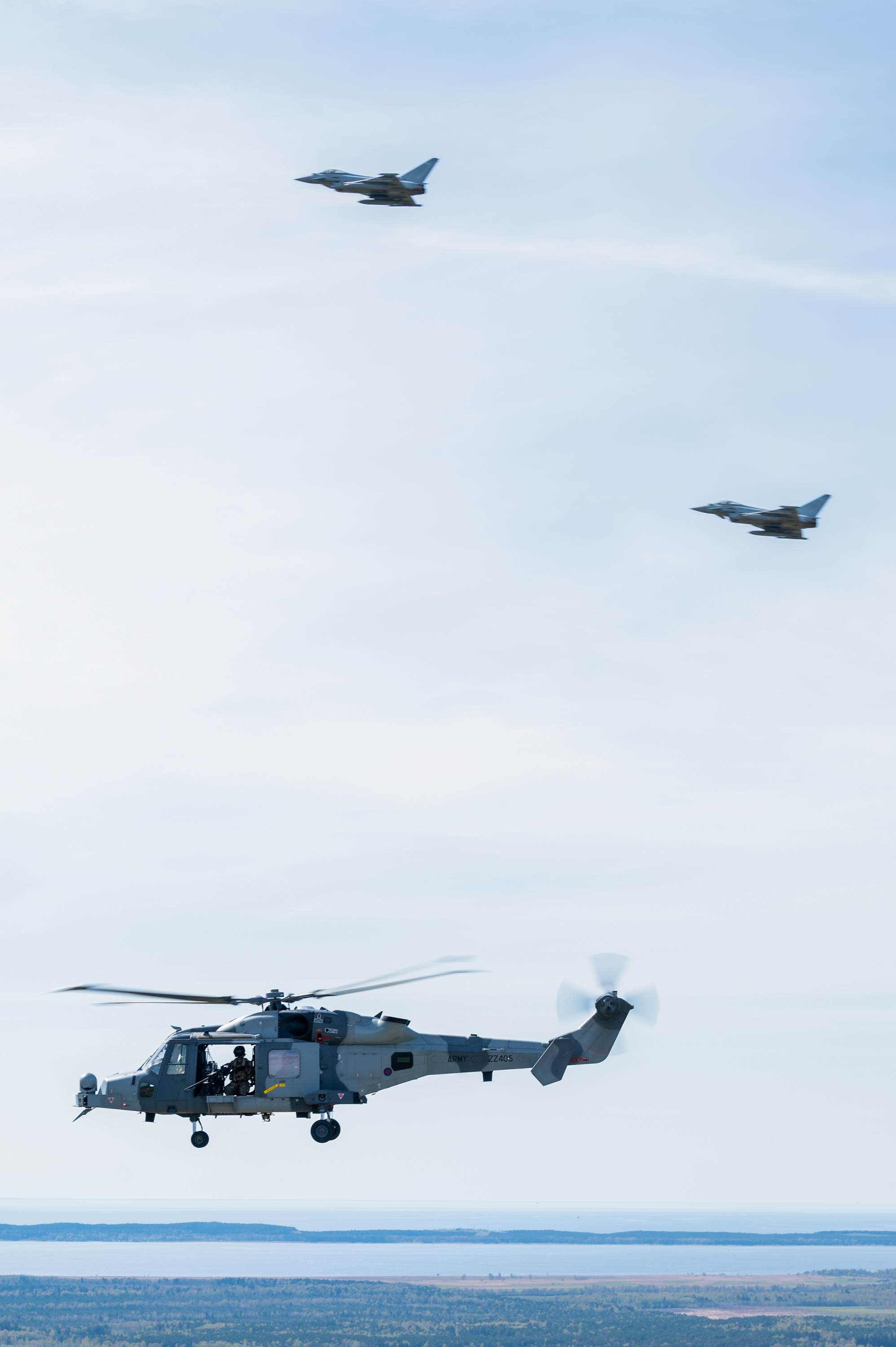 Two RAF Typhoons and a British Army Wildcat helicopter in flight.