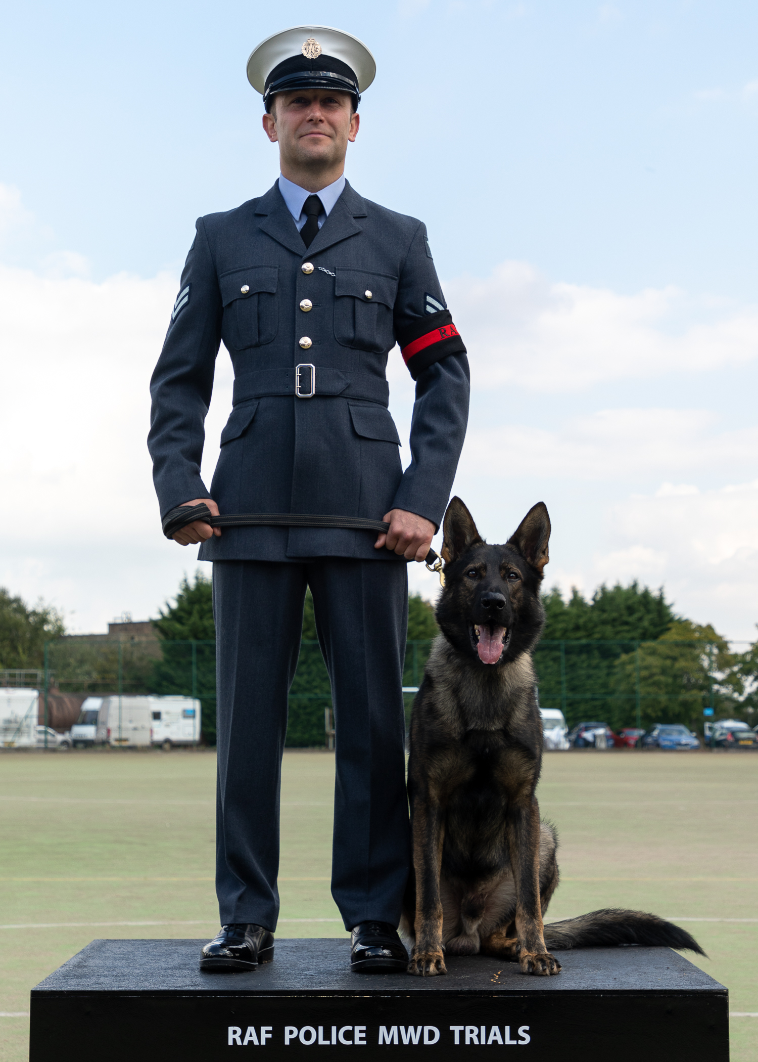 RAF Police Handler and dog stand on podium. 