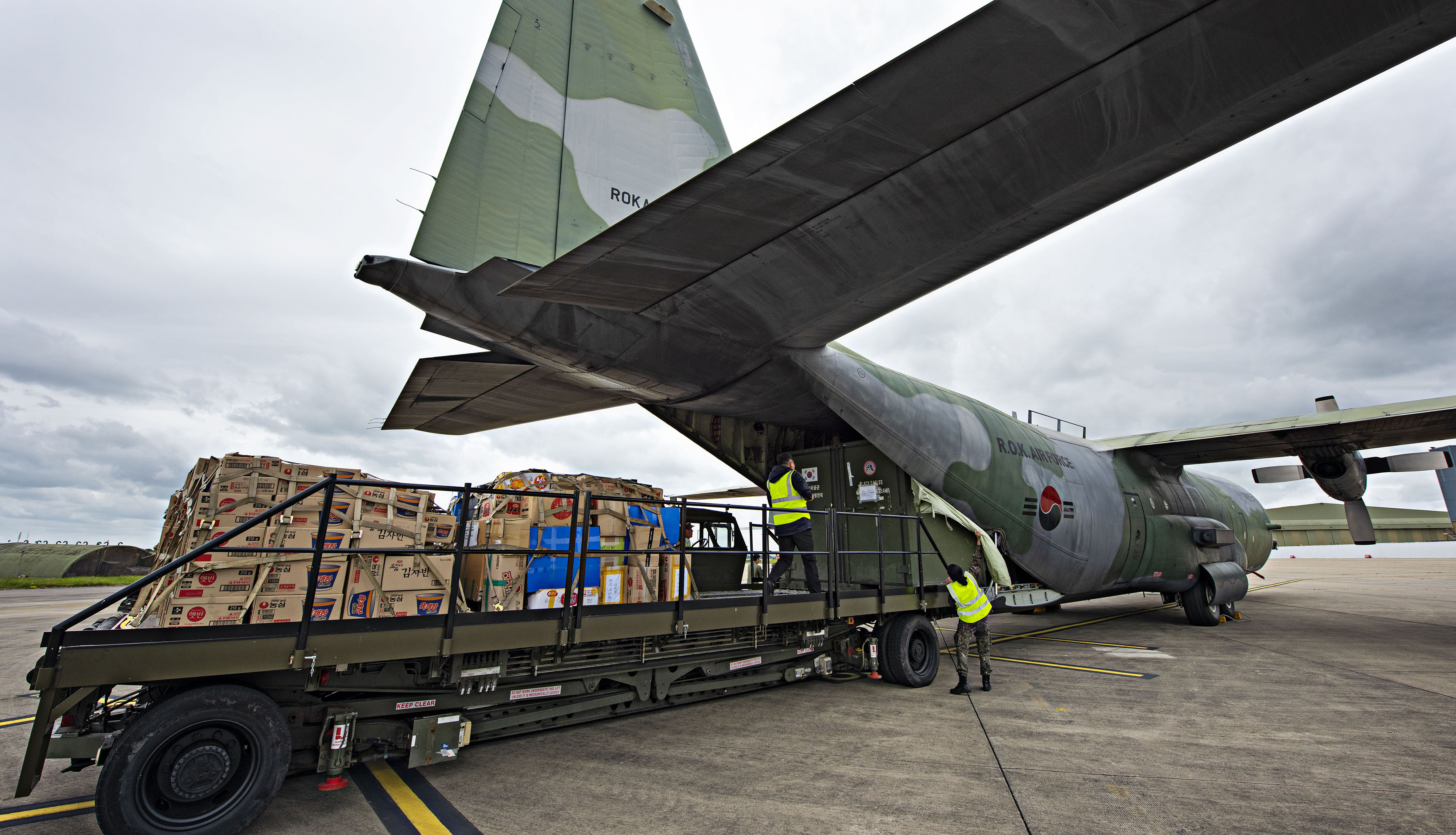 Image shows C-130 carrier aircraft with loading bay open and cargo.