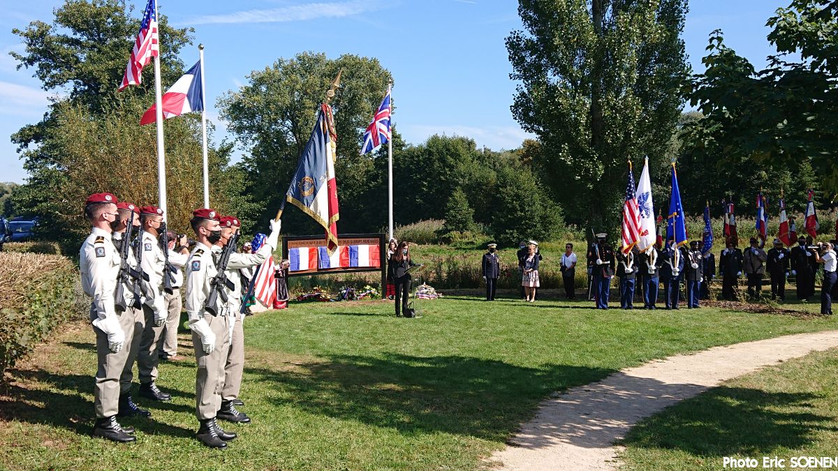 Flags flying by the memorial with Personnel and audience.