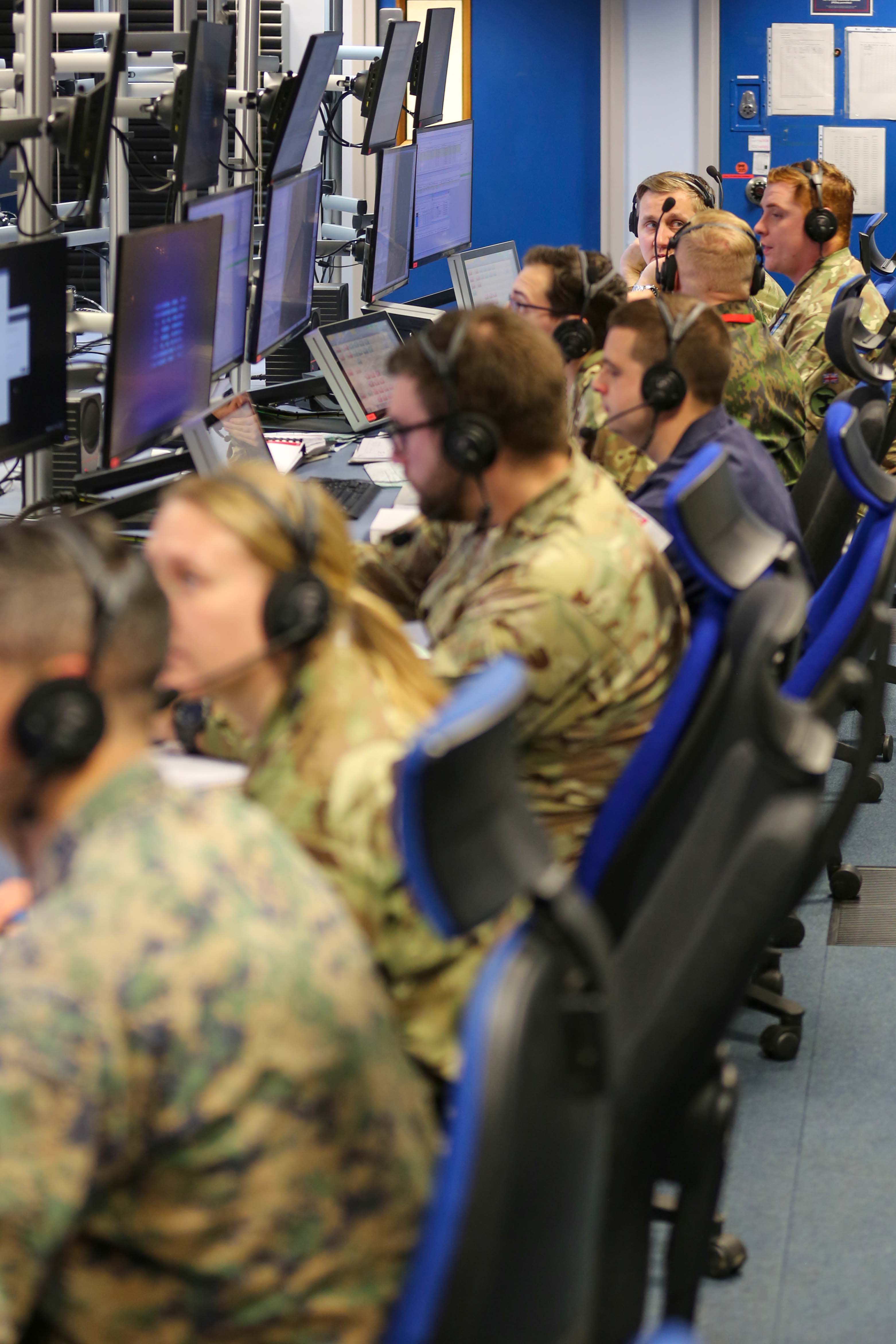 Image shows RAF personnel sitting at computer desks with headsets on.