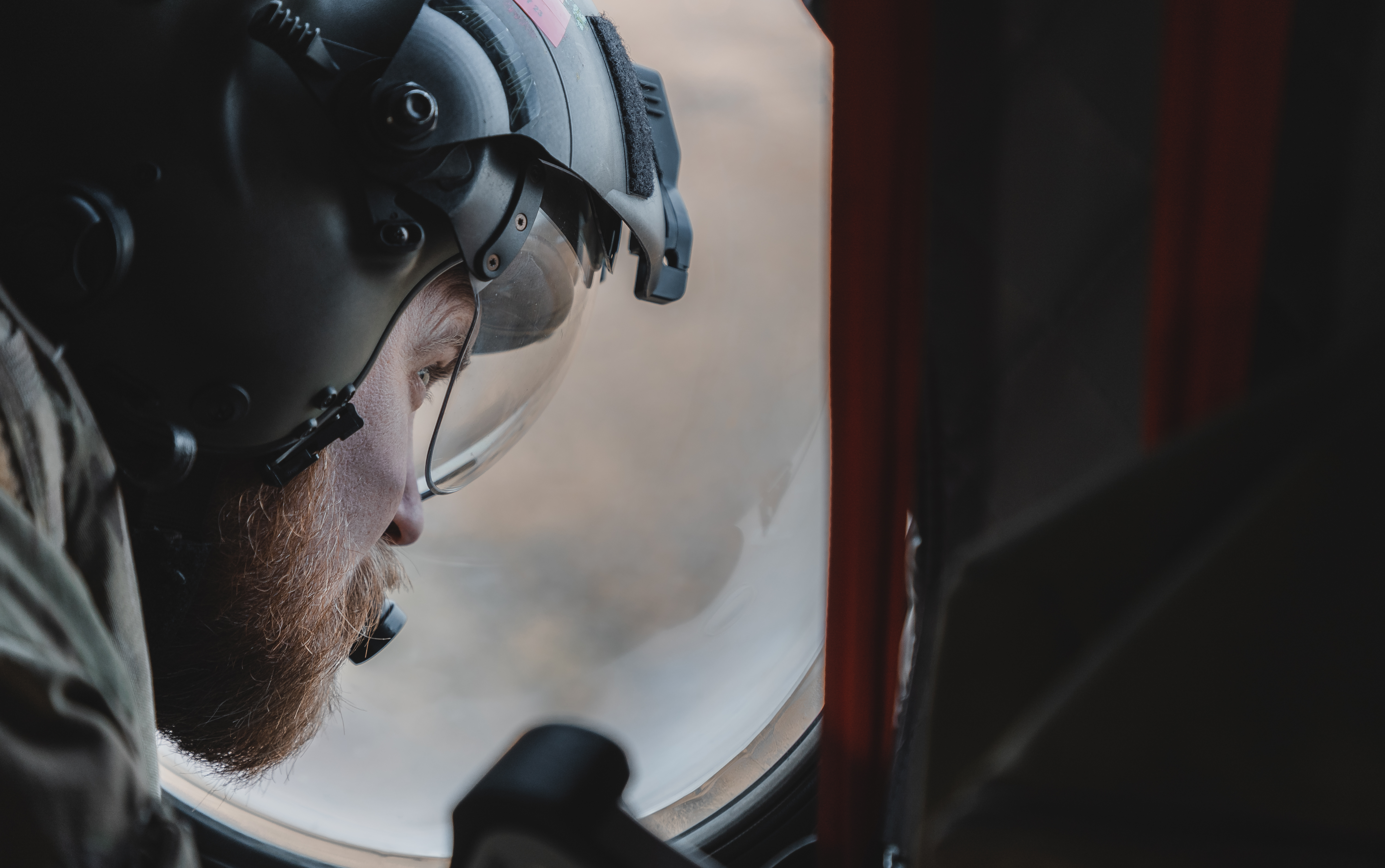 Image shows close up of a RAF Regiment wearing his helmet inside a Chinook.