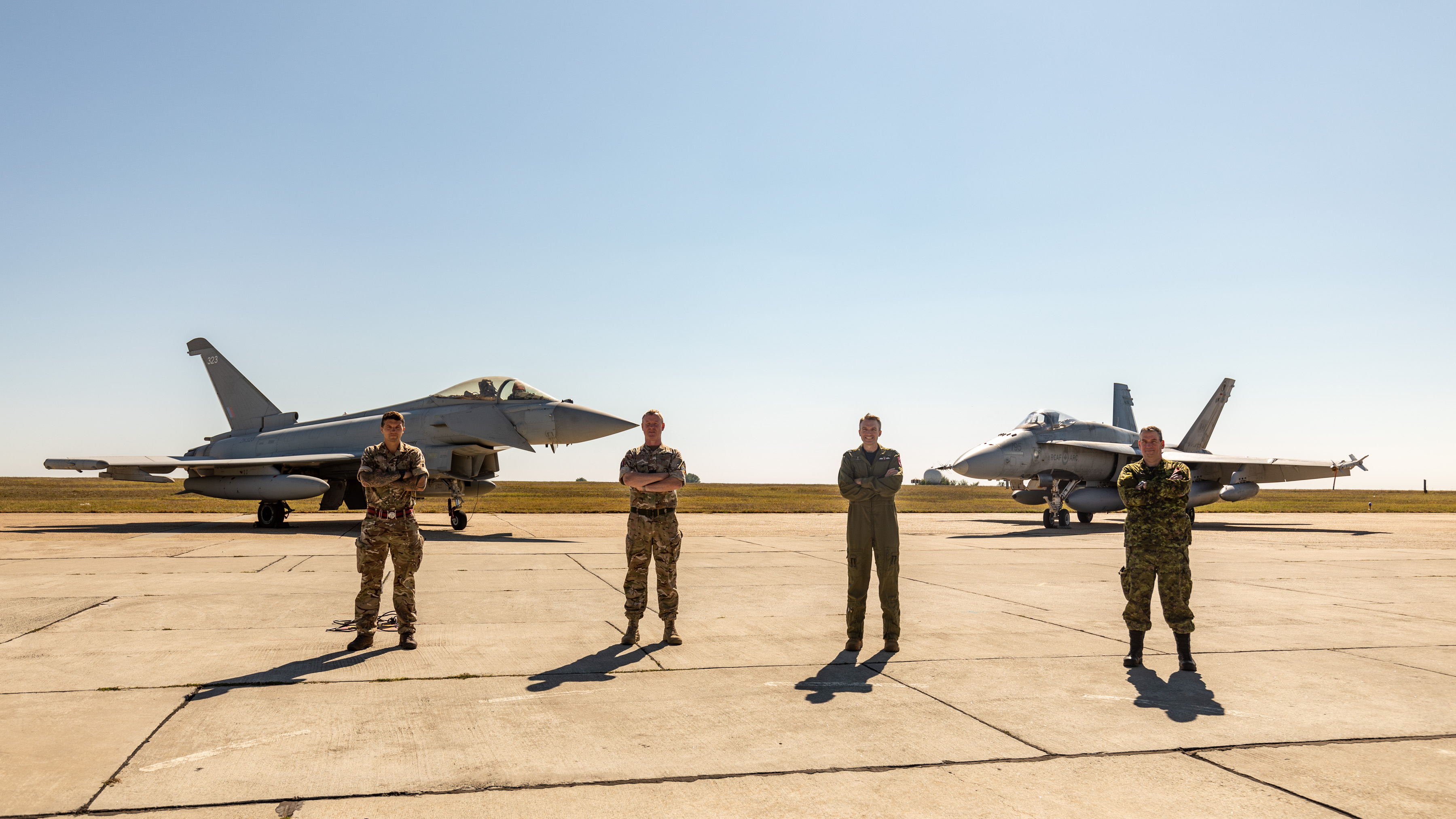 Four personnel stand in-front of two Typhoons.