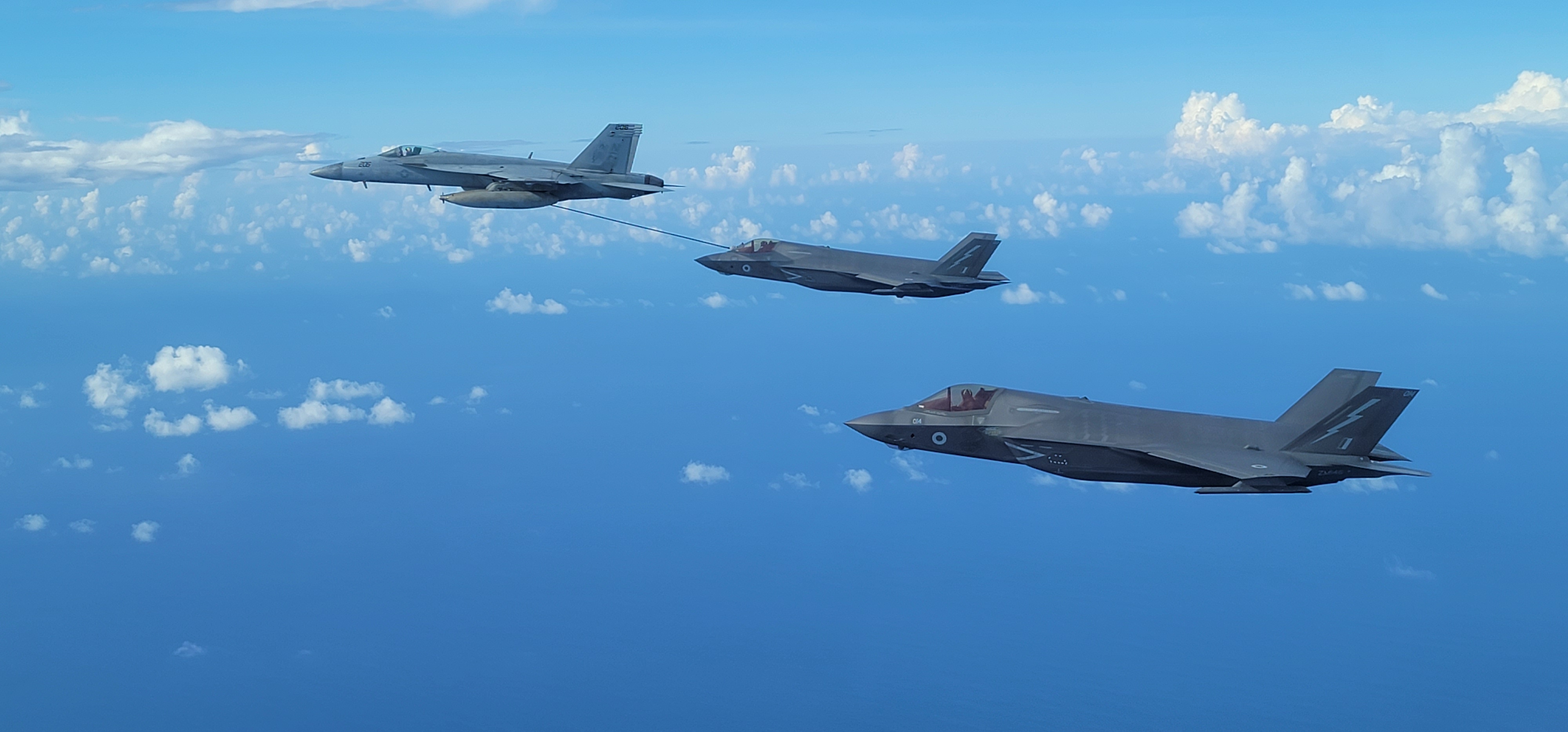 Two F-35B Lightnings and US Navy F/A-18E Super Hornet in flight.