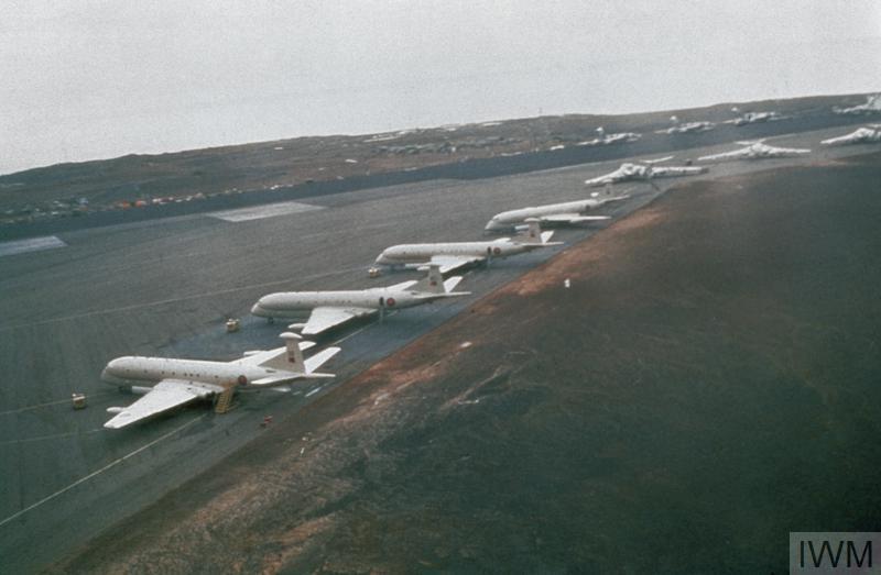 Aged image of aircraft lined up on an airfield.