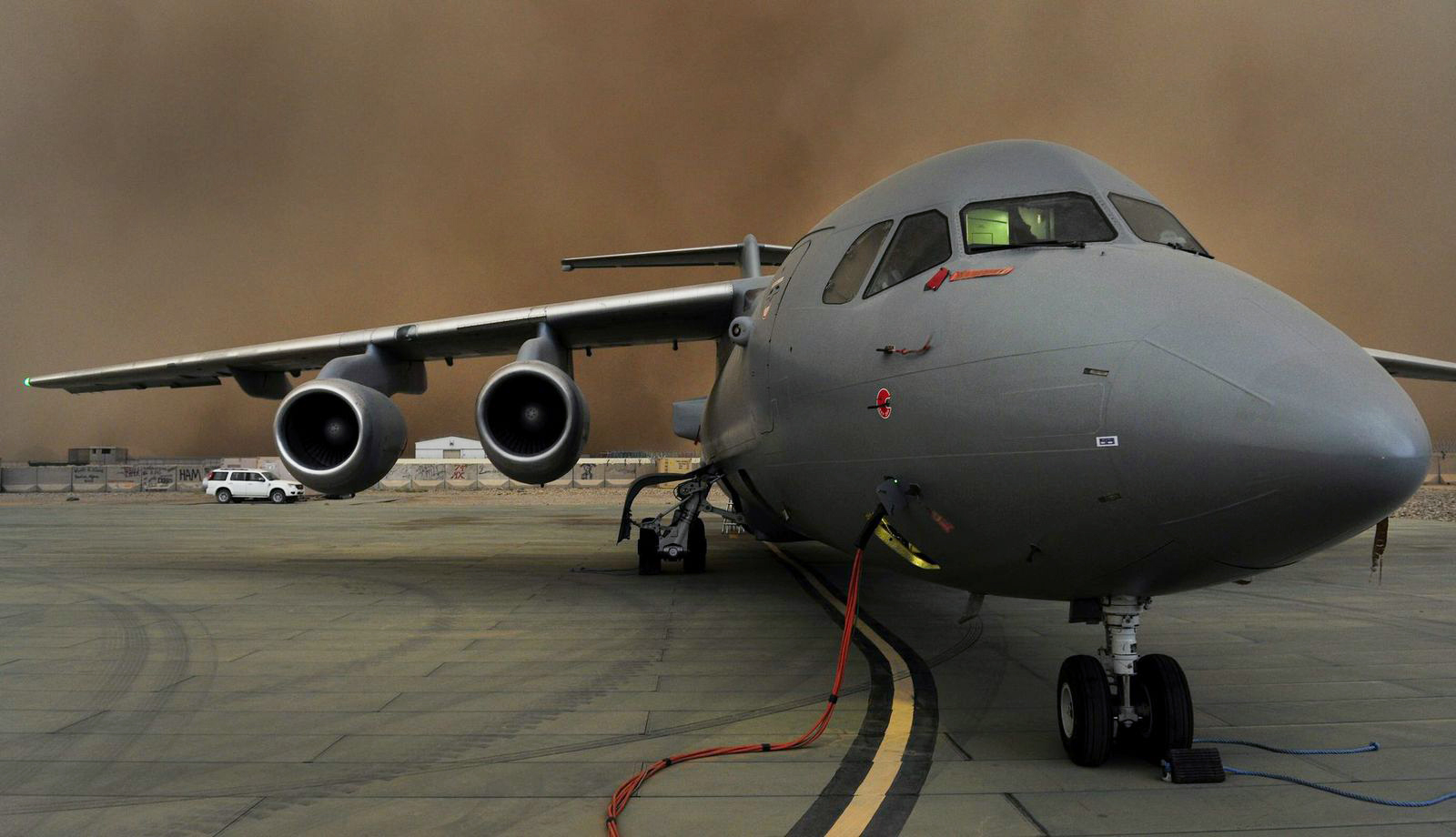 Nose shot of BAe146 aircraft on the airfield with smoke behind it.