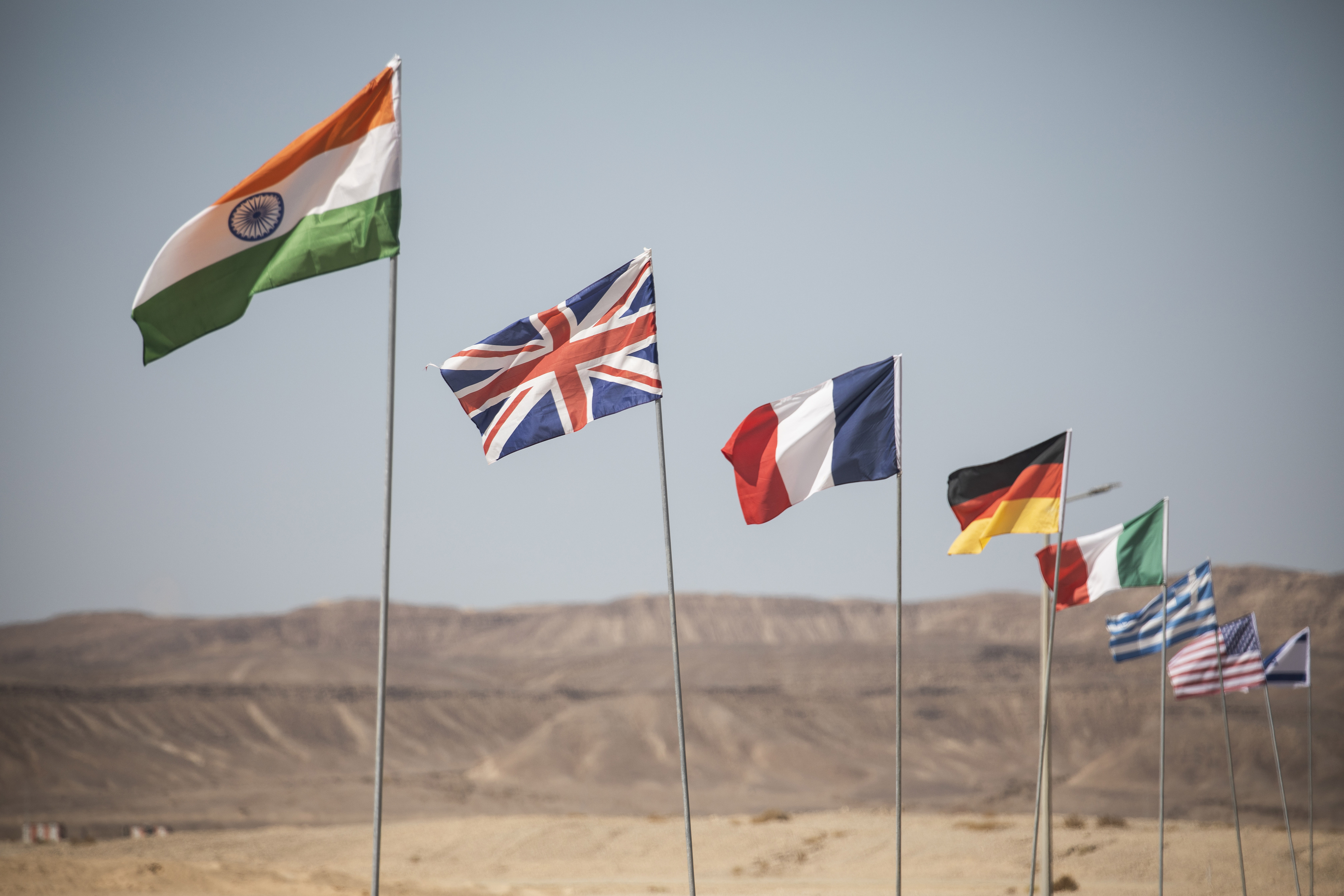 The flags of India, UK, France, Germany, Italy, Greece, USA and Israel flying in the wind.