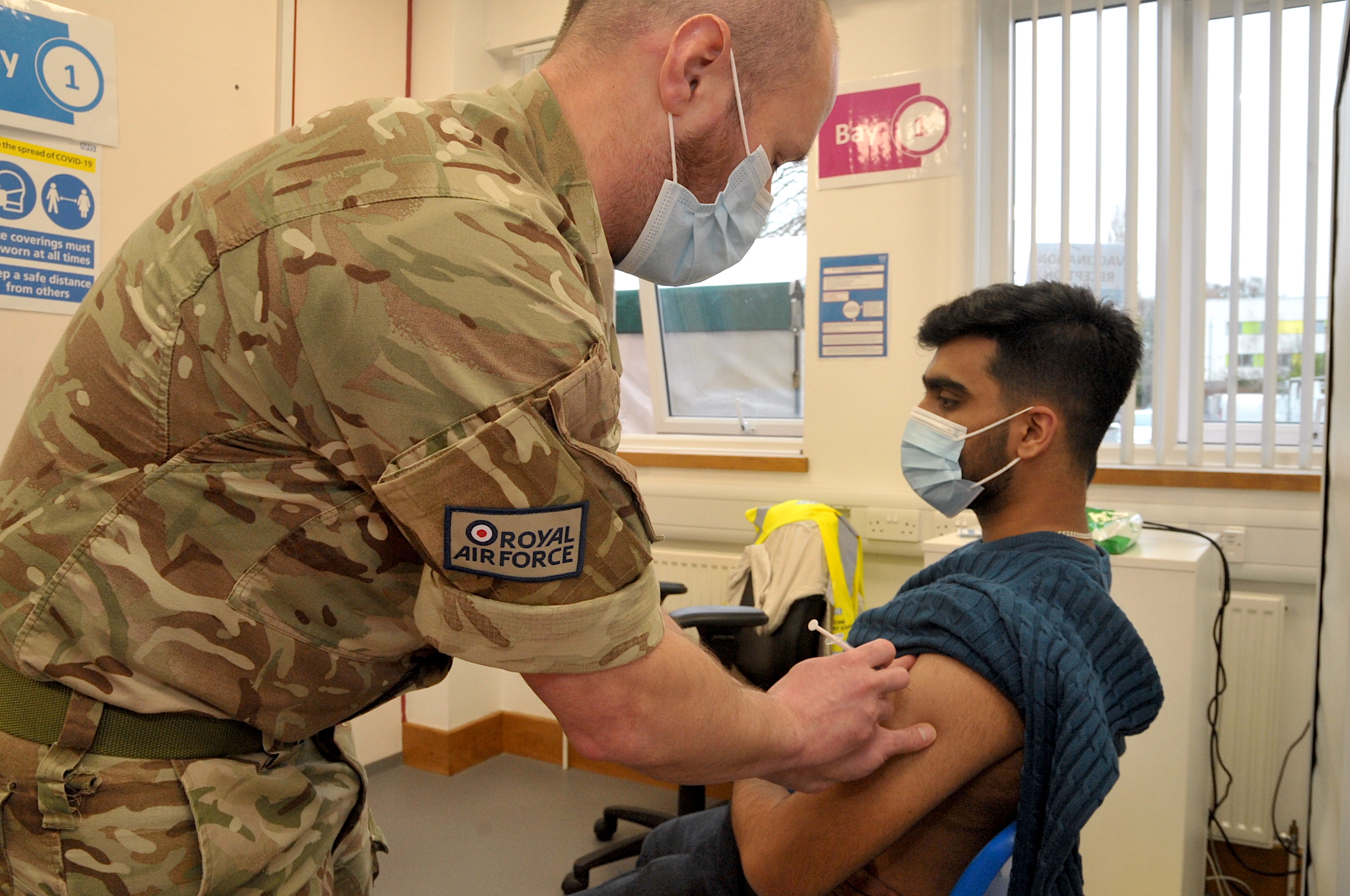 Image shows RAF personnel administering a vaccine.