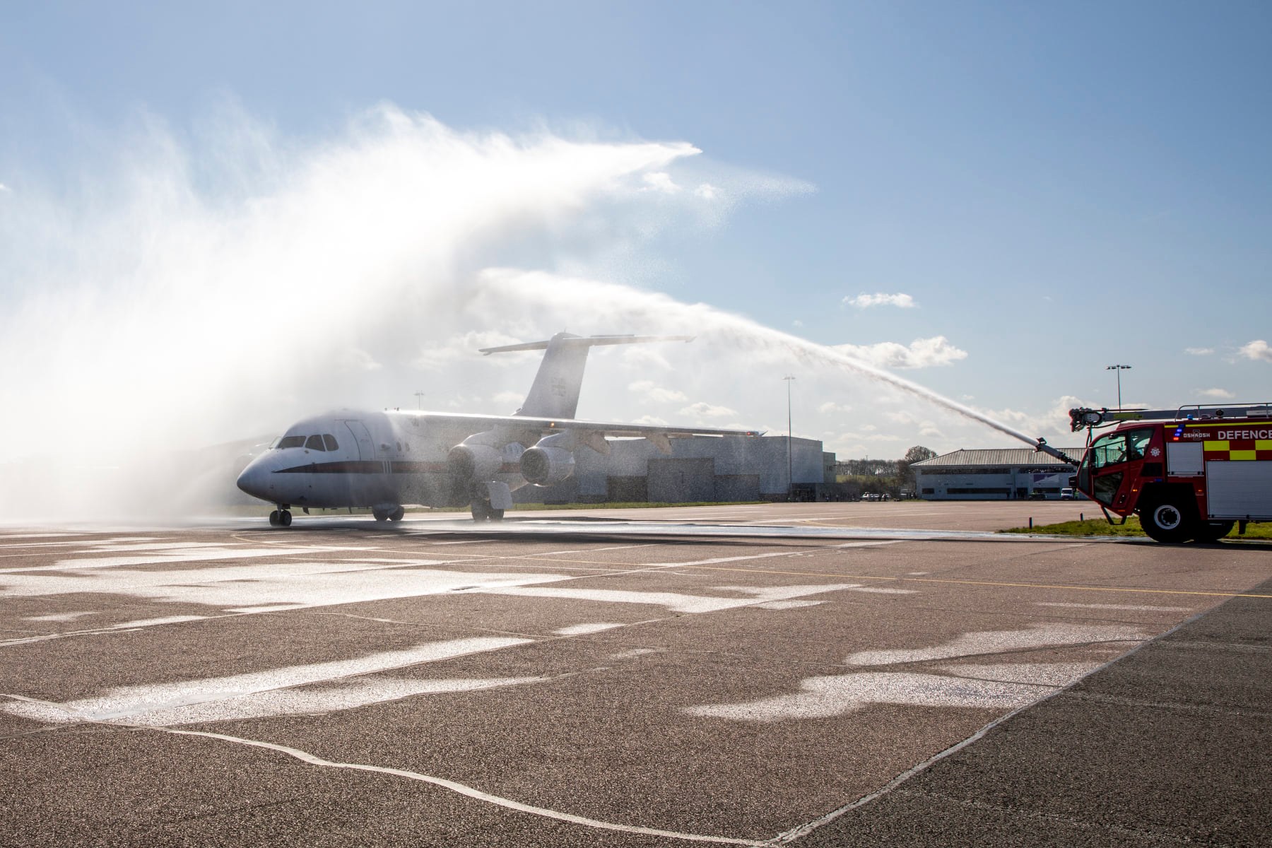 BAe146 aircraft being sprayed with water by fire engine.