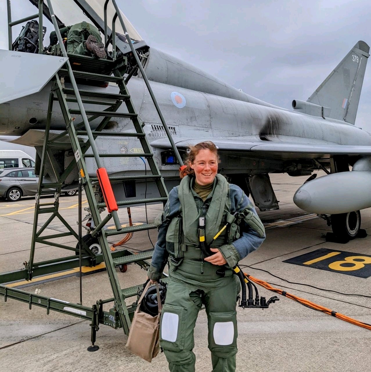 Image shows RAF pilot carrying luggage by a Typhoon on the airfield.