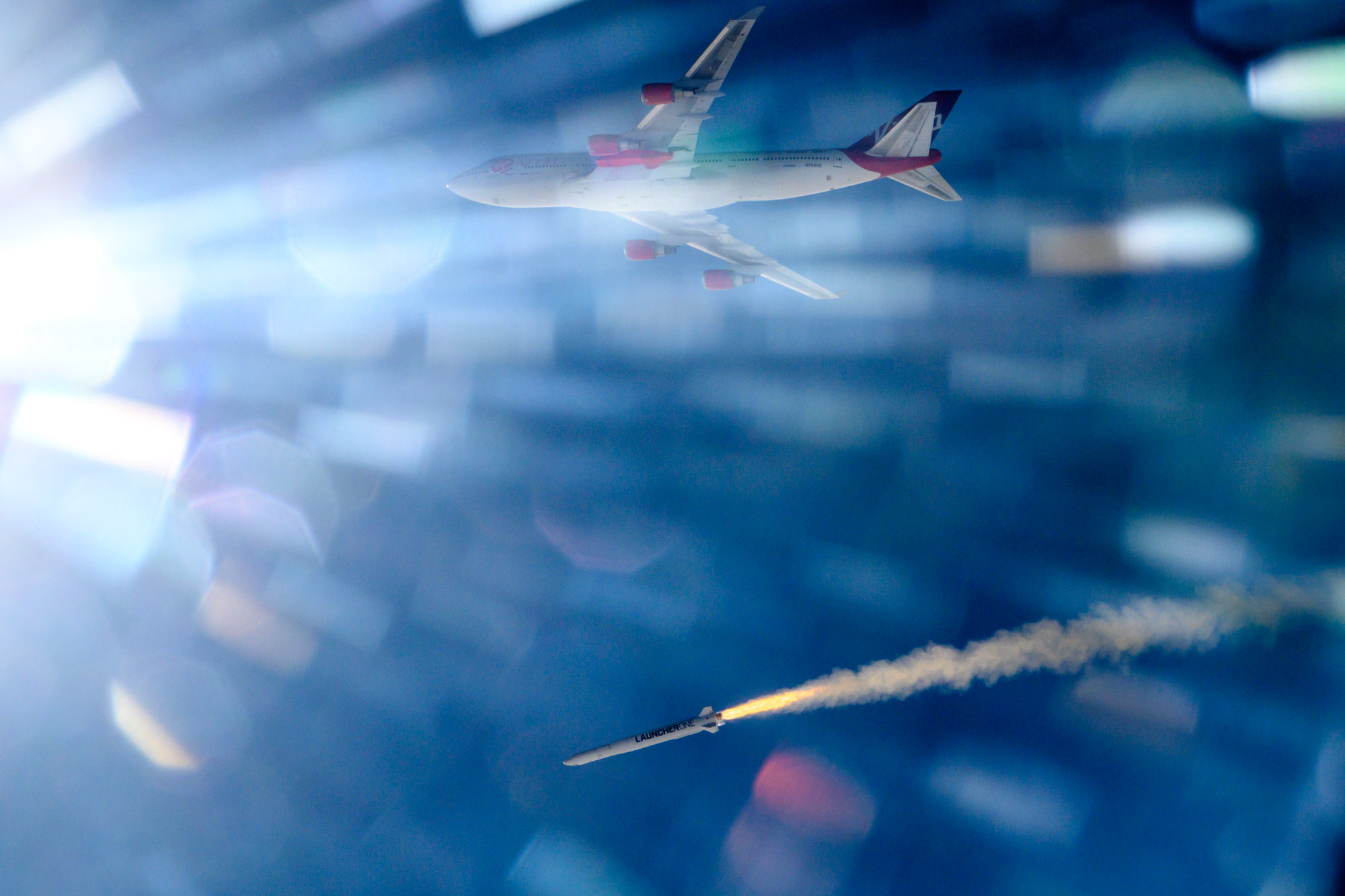 Rocket and Virgin Orbit Boeing aircraft in the sky; sunlight rays blur the view.