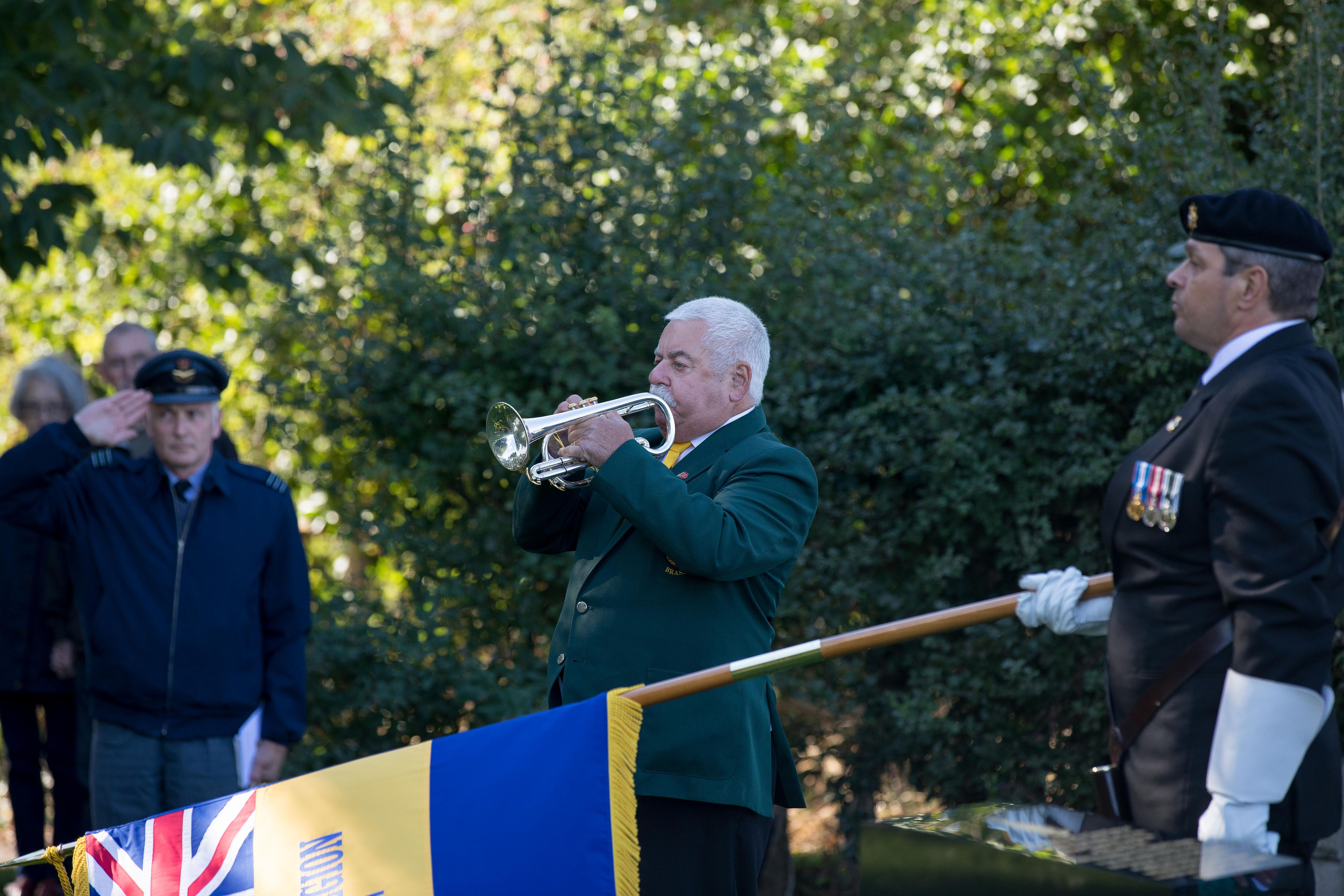 Personnel plays a bugle at service.
