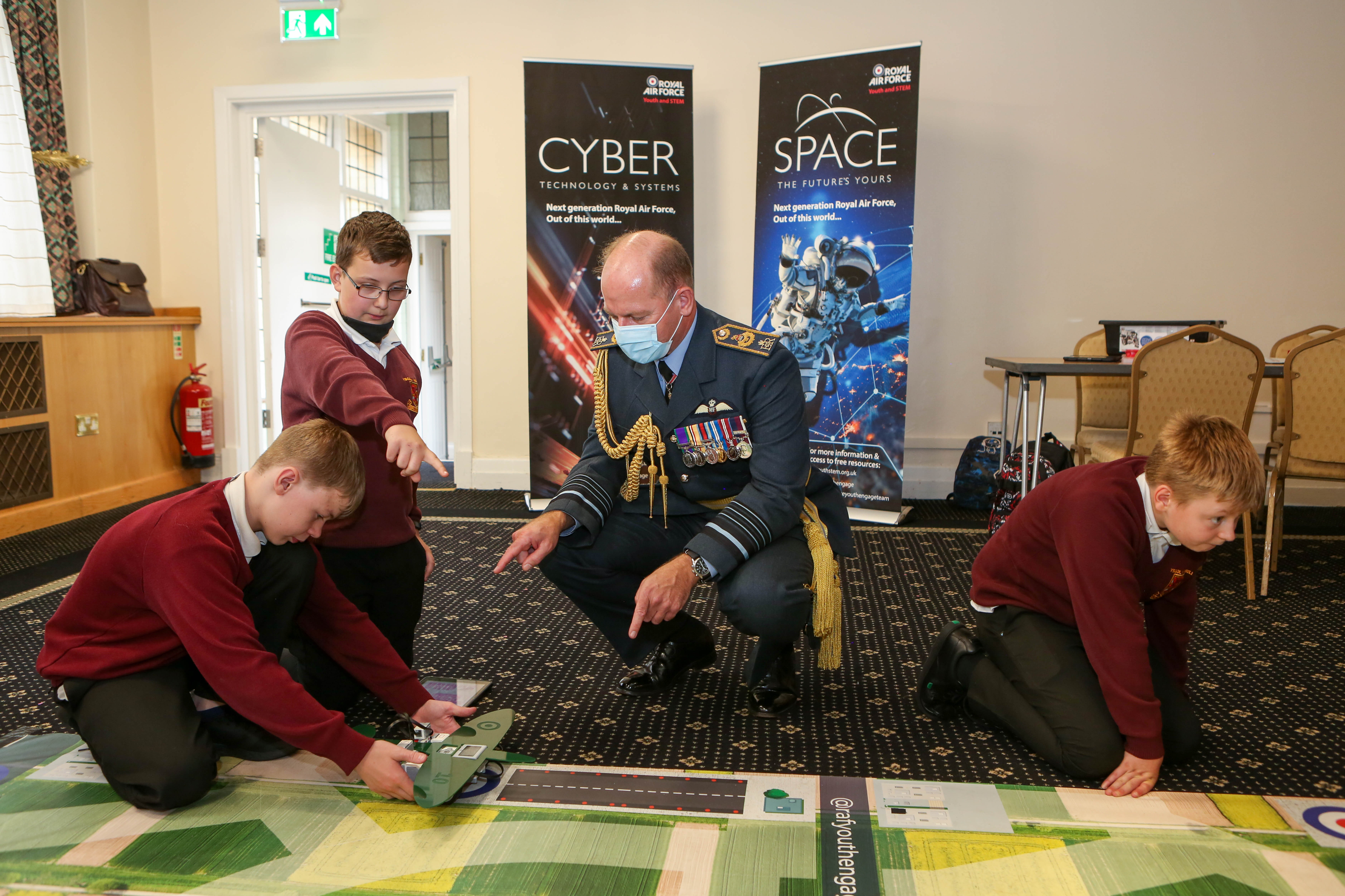 Air Chief Marshal Wigston with school children working on the floor.