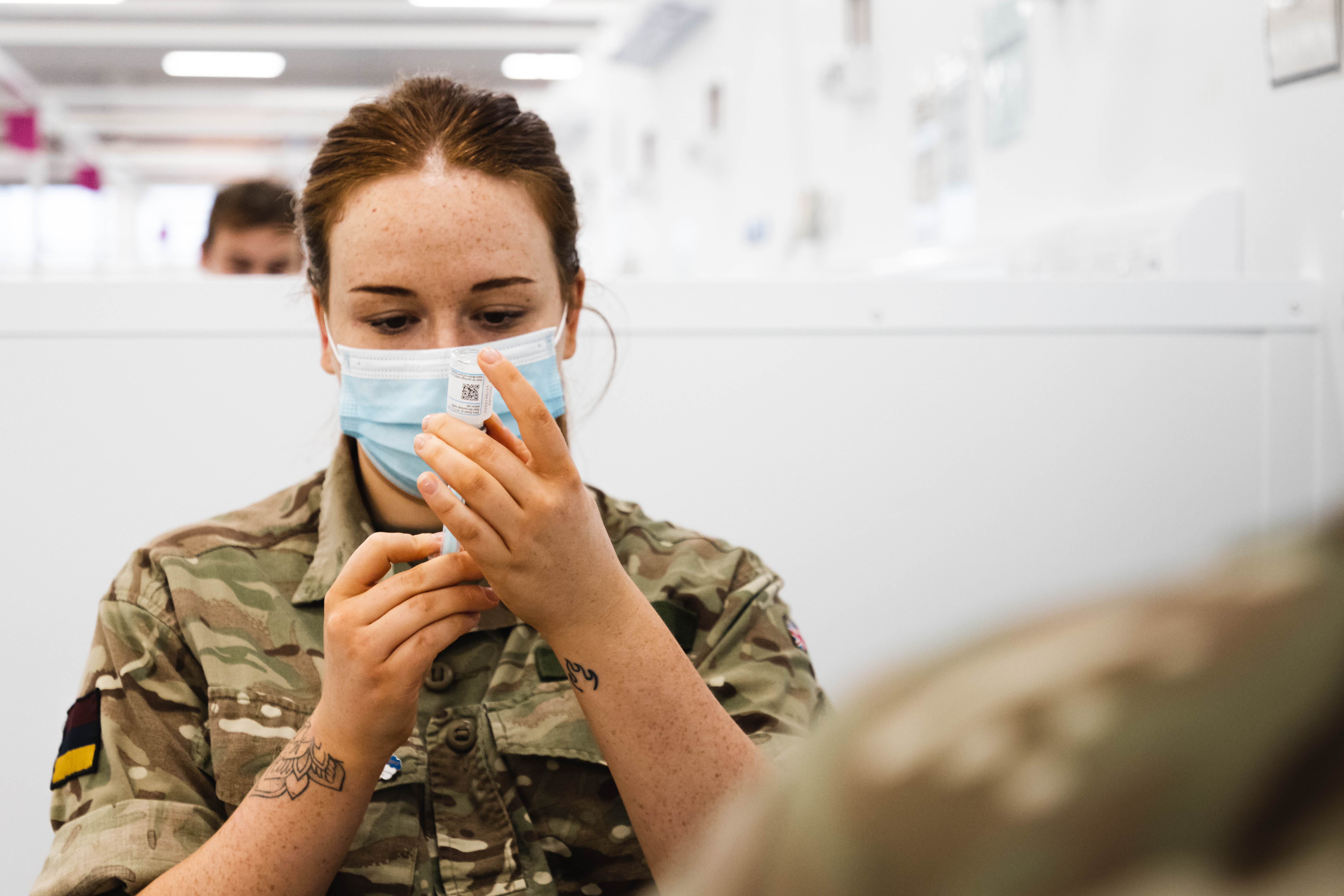 Personnel looks at vaccine.