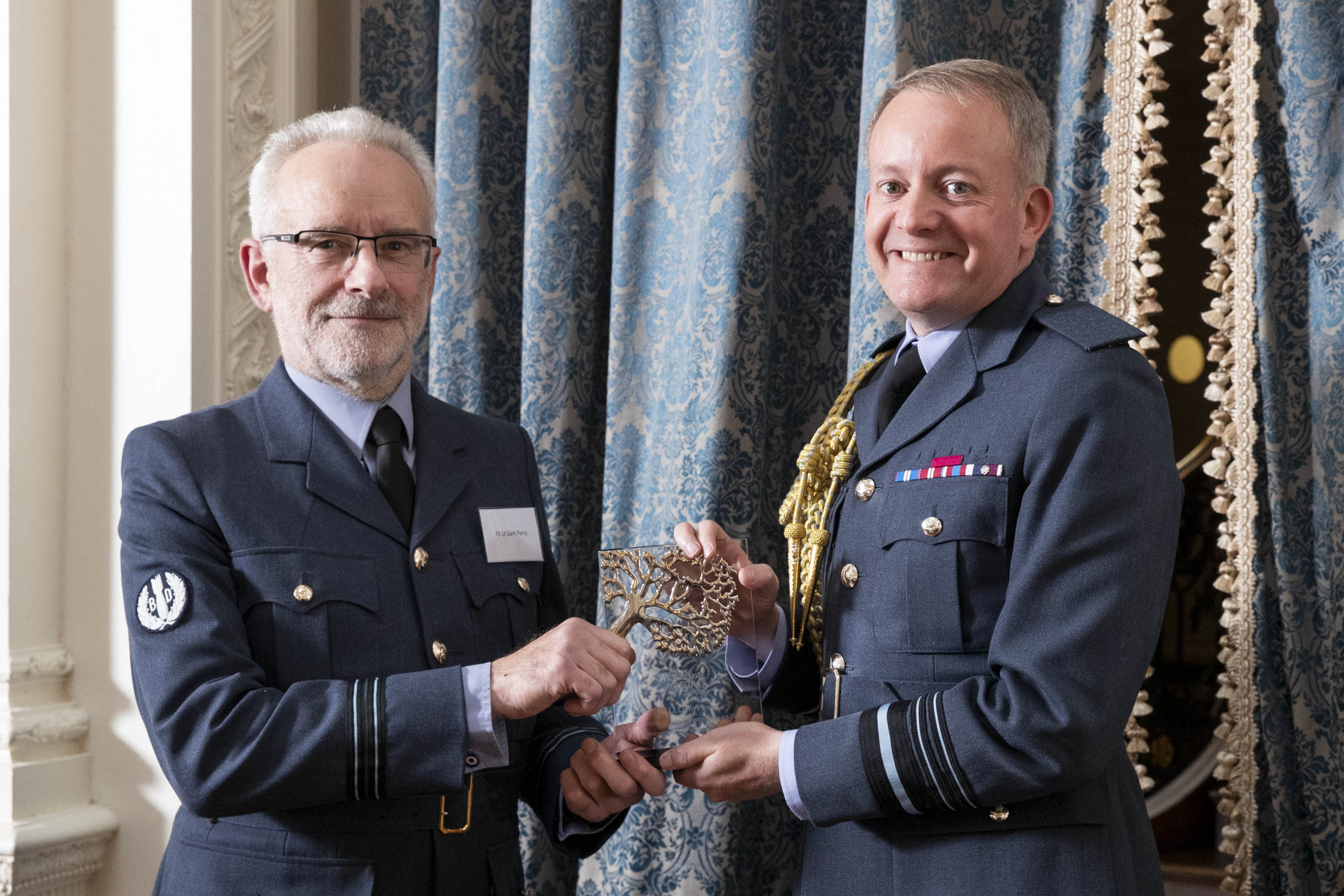 Image shows RAF personnel holding glass award.