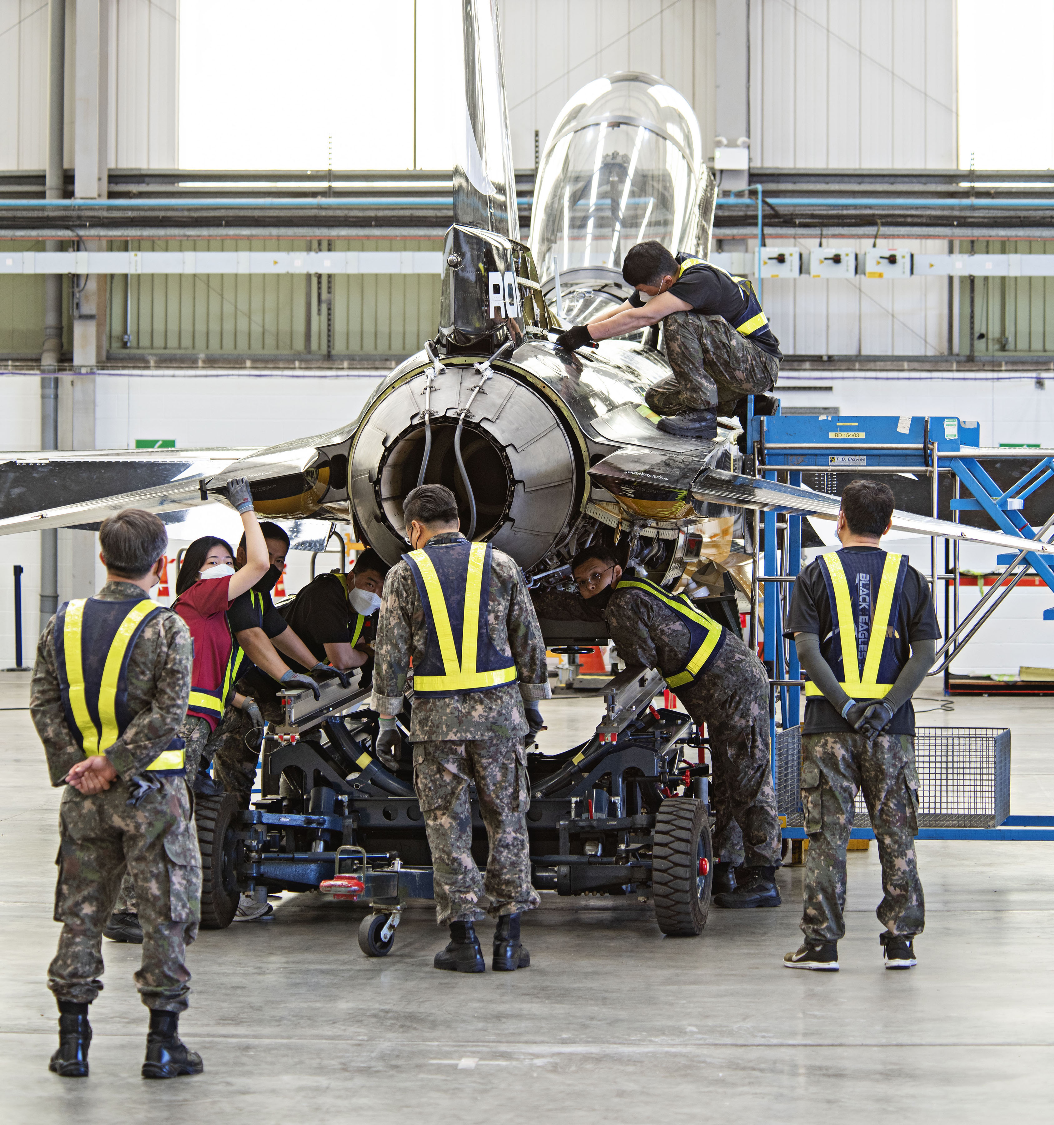 Image shows Korean Air Force Pilots working on Black Eagle aircraft parts.
