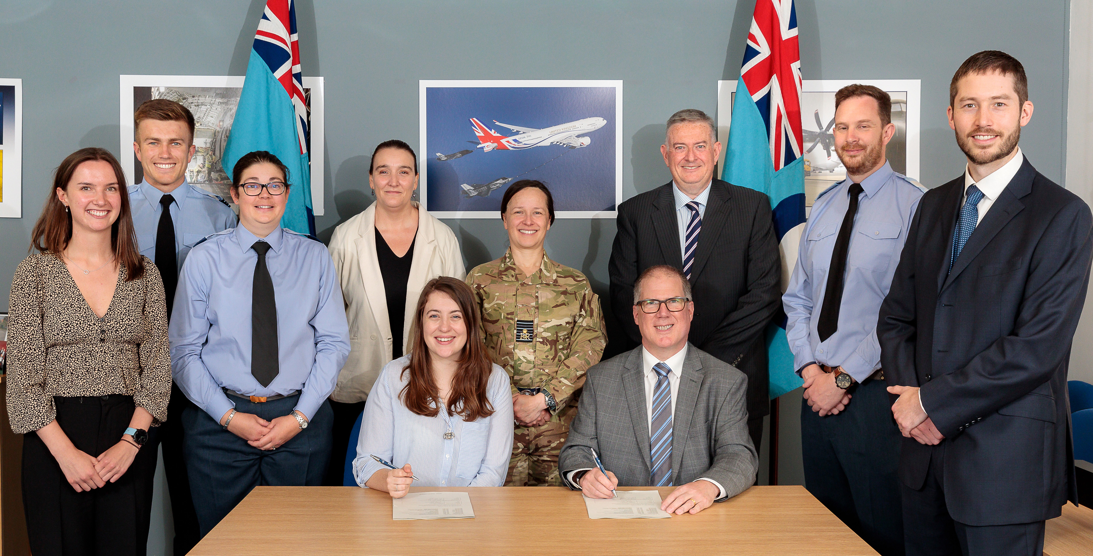 Image shows aviators and civilians standing around a table.