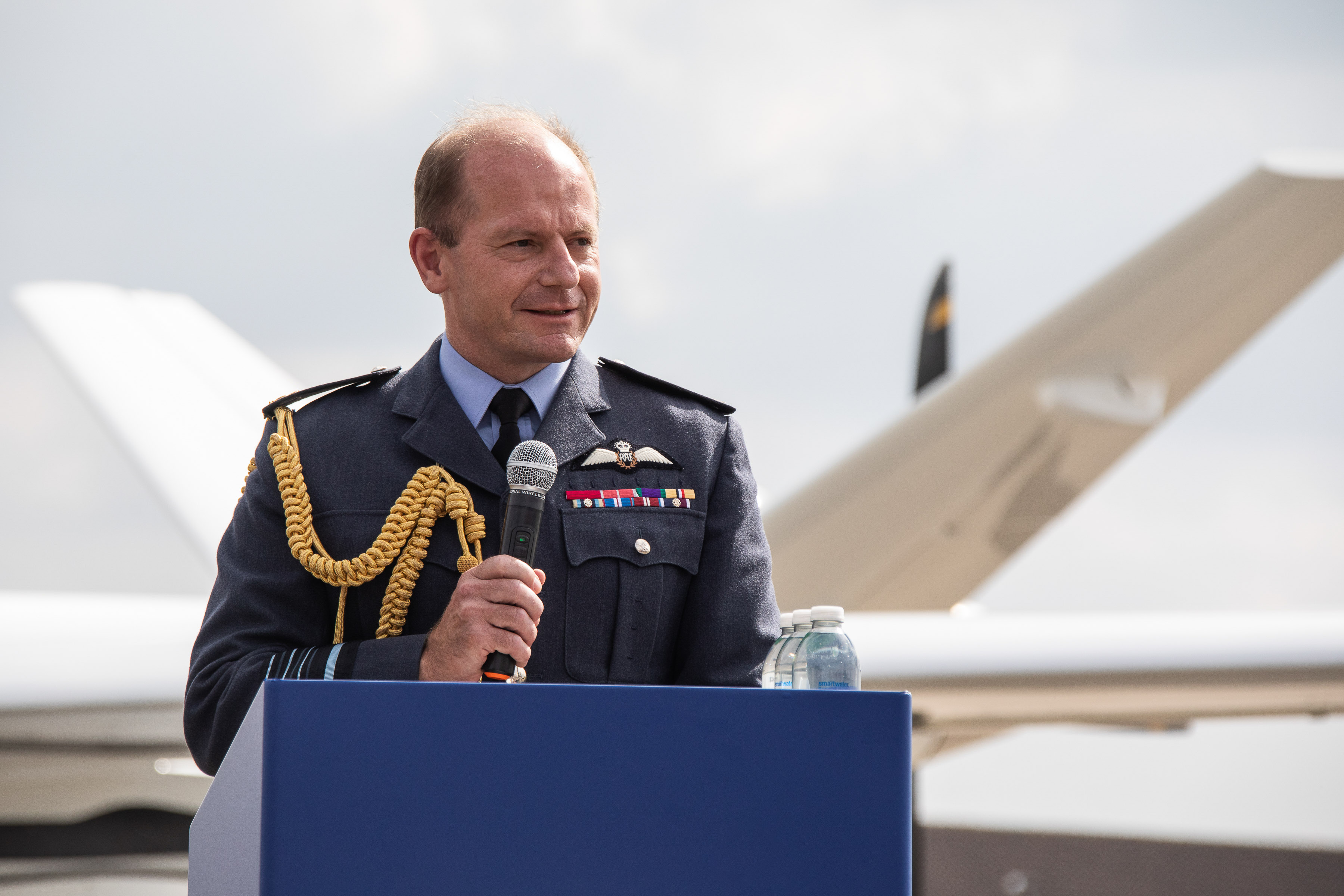 Image shows the Chief of the Air Staff, Air Chief Marshal Sir Mike Wigston speaking in front of the SkyGuardian aircraft.