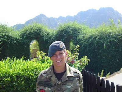 Corporal Moncaster smiling in uniform outside.