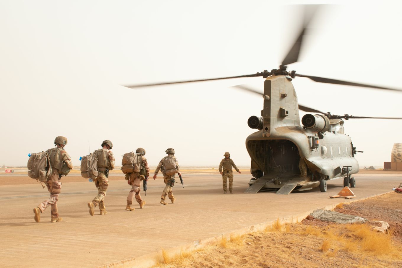 French troops walk towards an RAF Chinook.