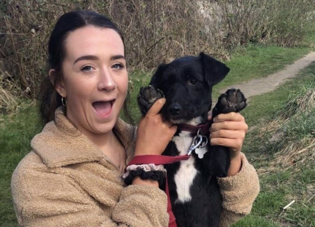Beth smiles while holding a dog.