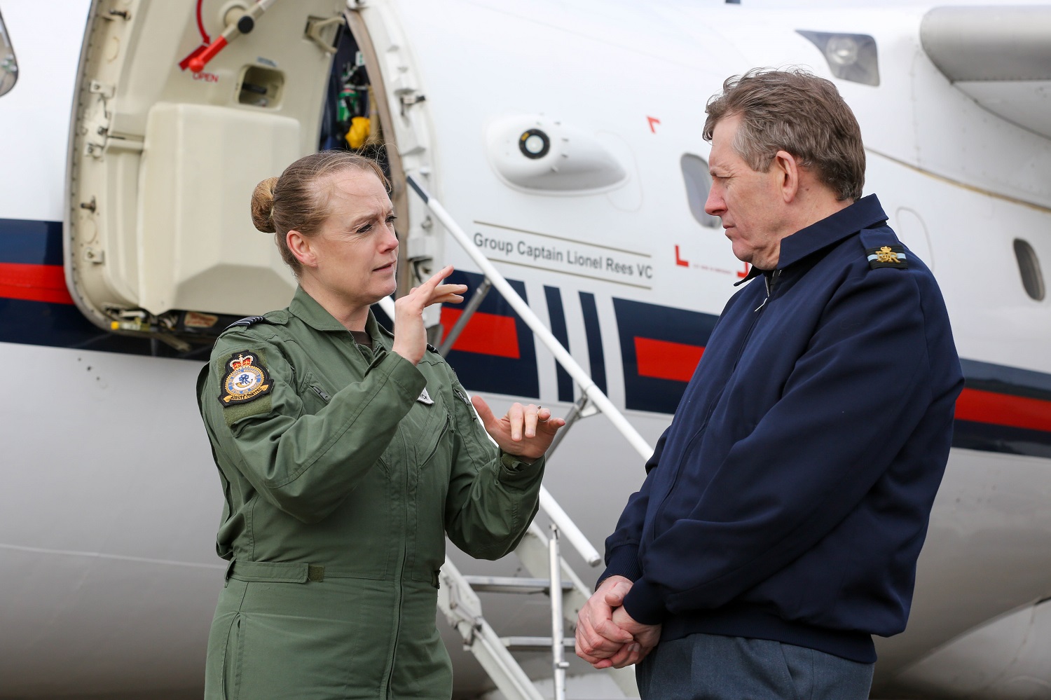 Personnel talk outside BAe146 aircraft.