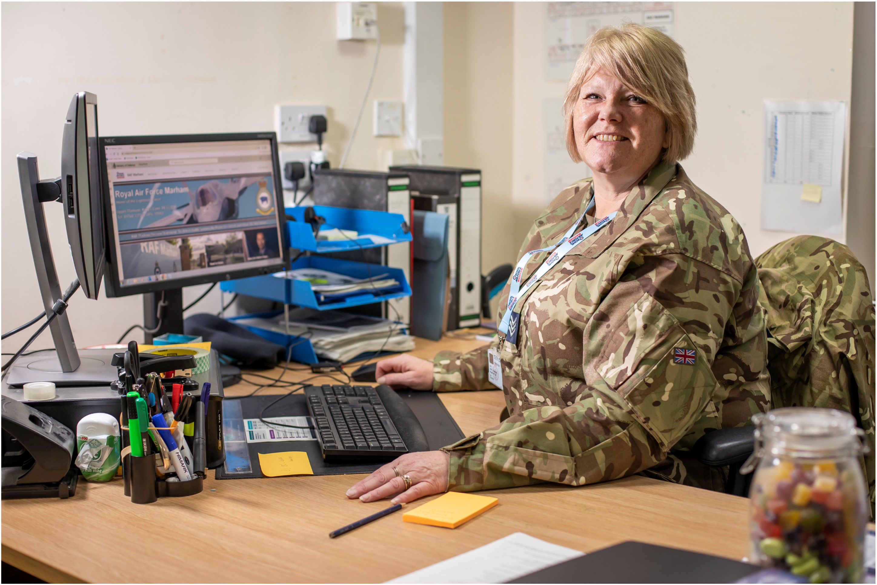 RAF reserve smiling, sat at a desk
