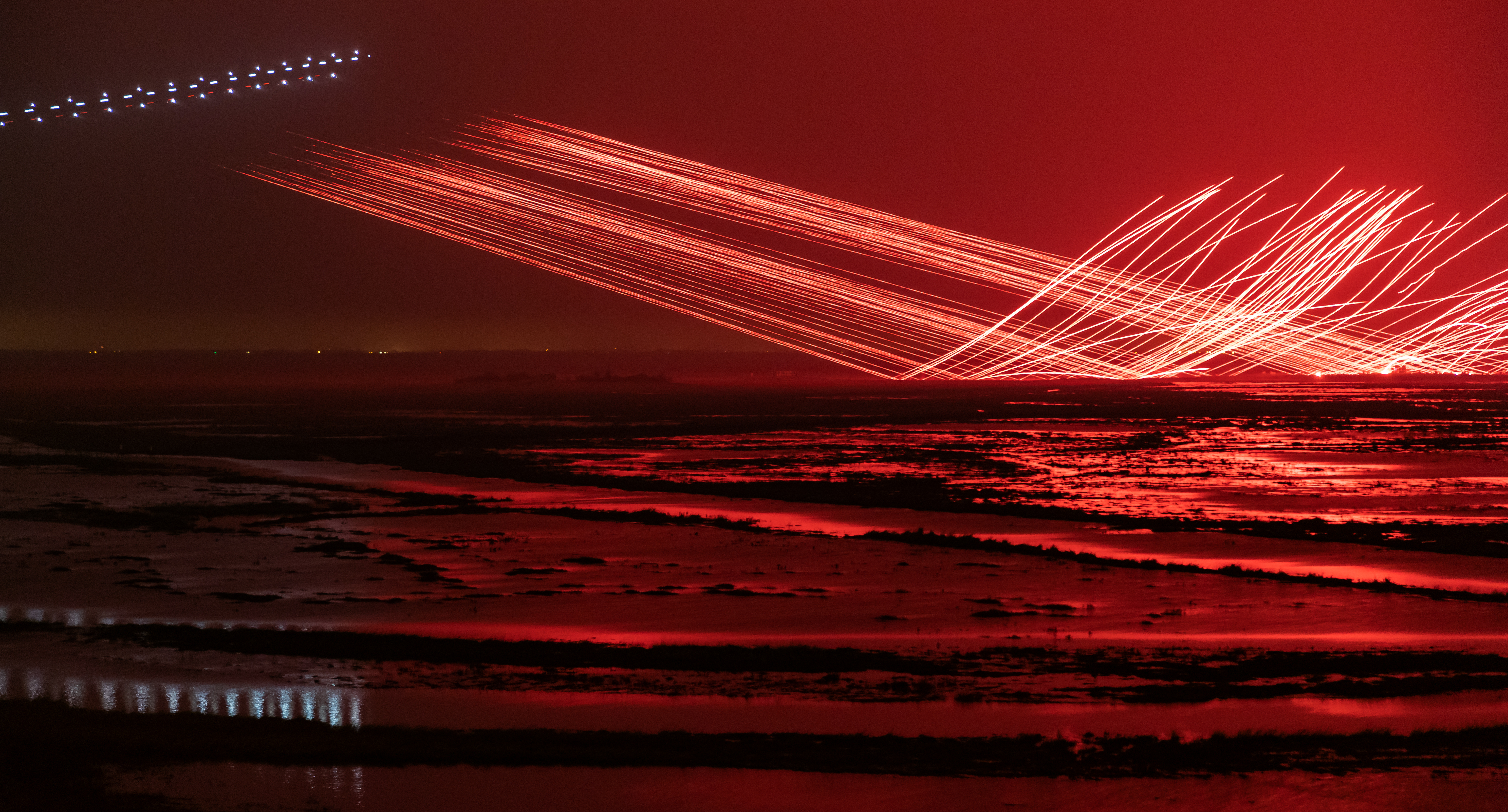 Image shows firing artillery over the beaches at night. the airfield and its cargo bay open.