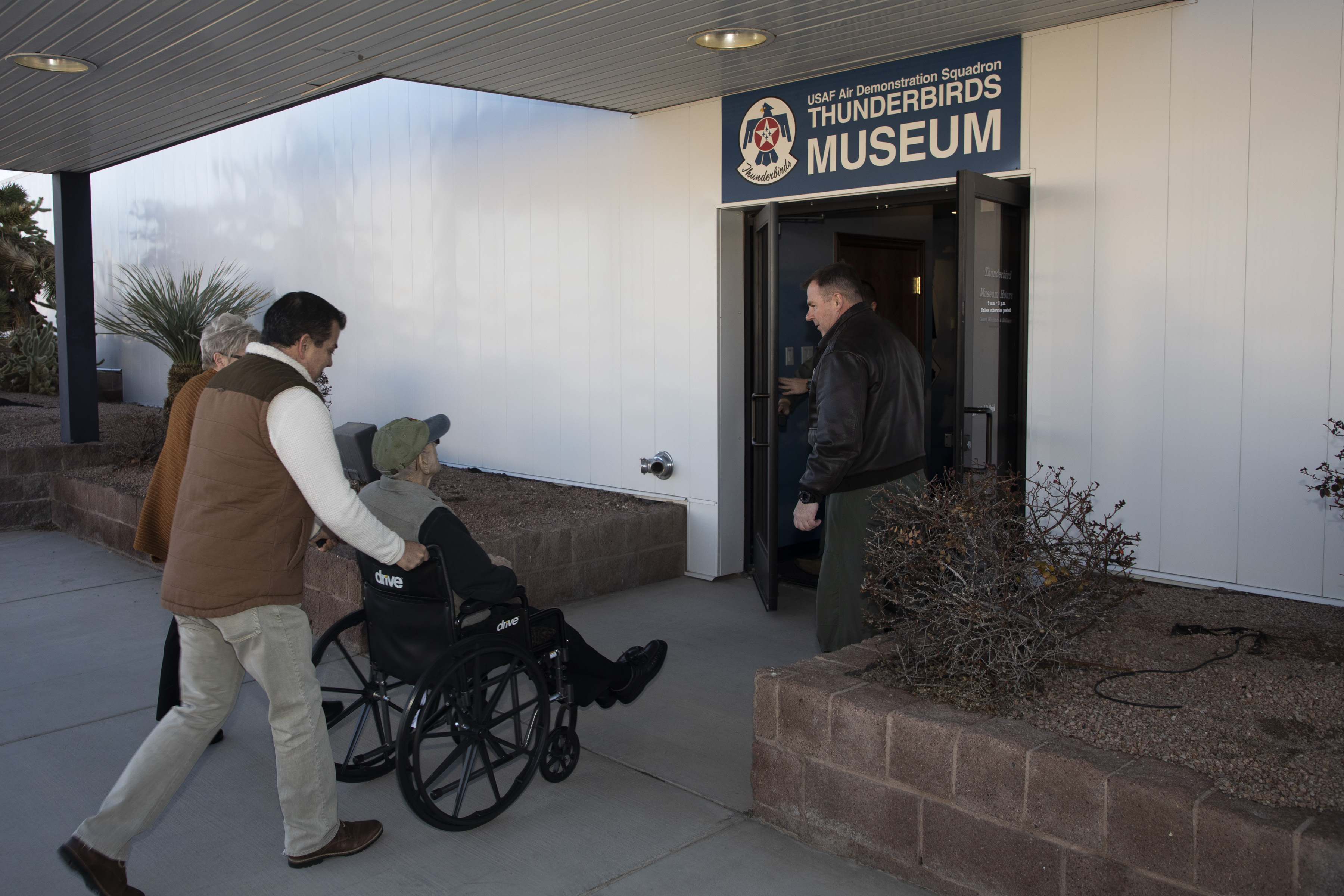 Image shows RAF Veteran and civilians entering Thunderbirds museum.